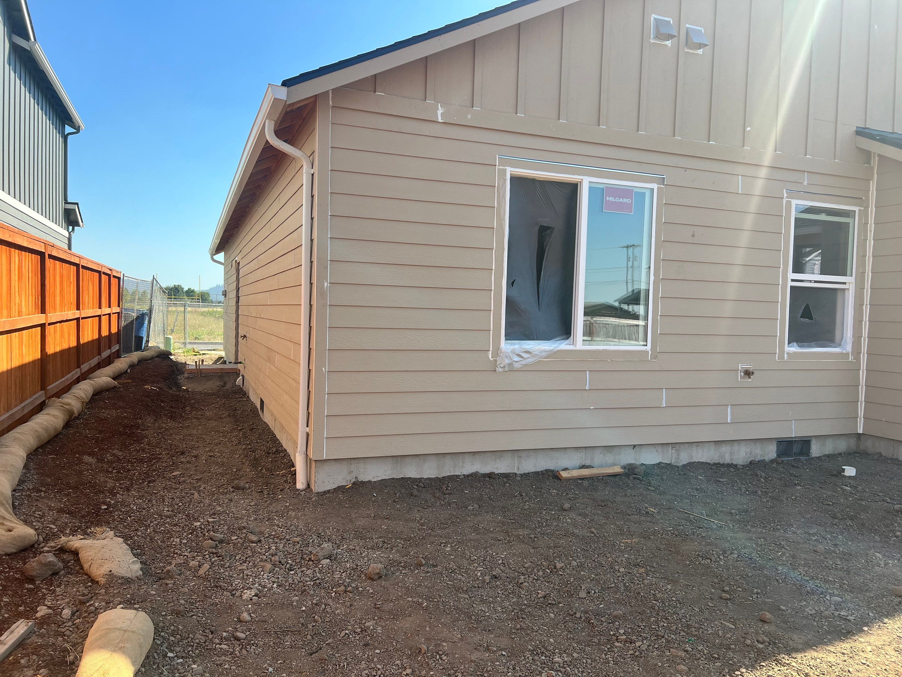 Continuous White Gutter and Downspout Installation for New Eugene Home by BEST Roofing & Waterproofing
