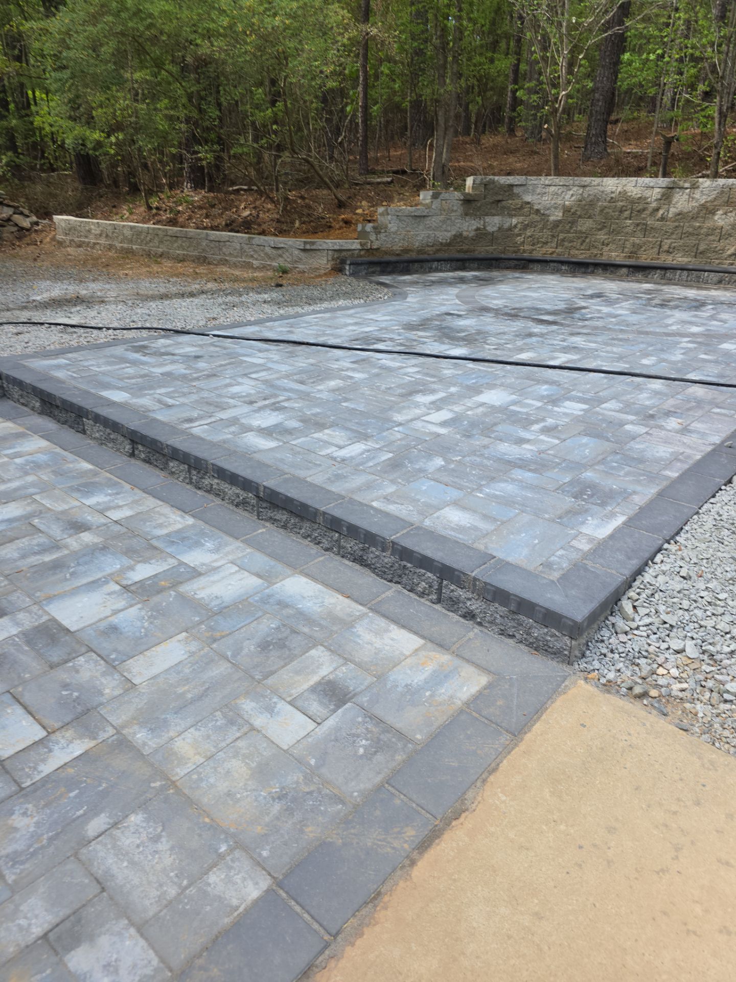 Pittsboro Outdoor Living Transformation – Retaining Wall, Paver Patio & Elevated Deck by Elite Remodeling and Design LLC