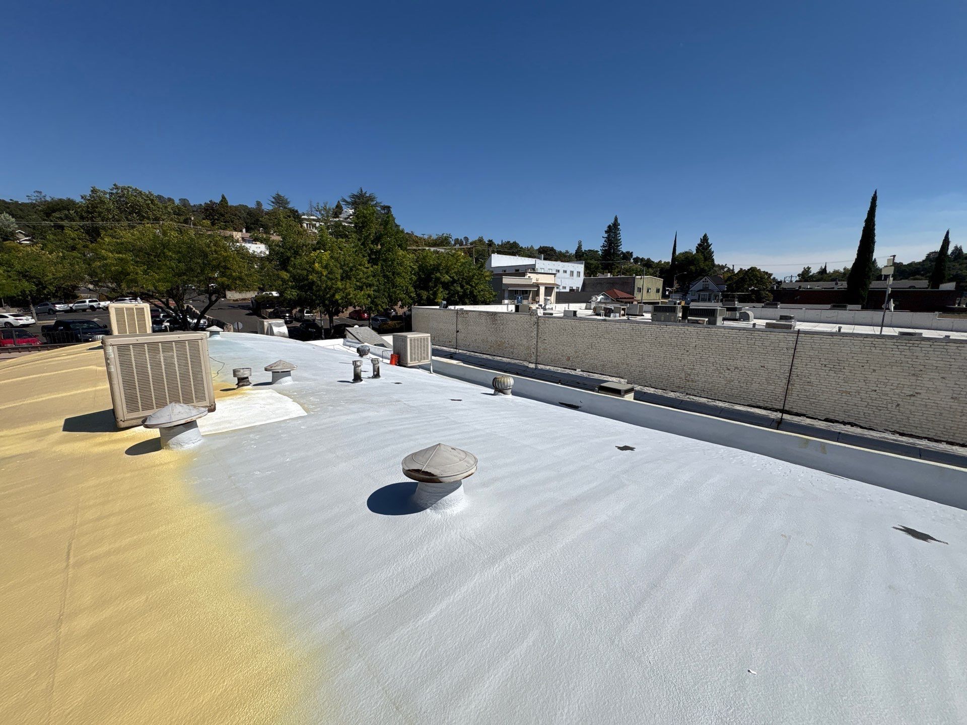 Foam and coatings on commercial roof by Straight Edge Roofing Inc