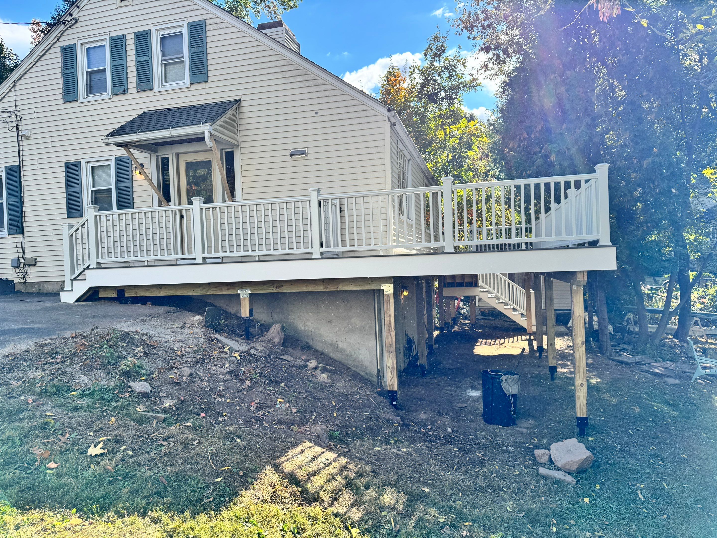 New Deck, Trex Select Pebble Gray boards, Composite railings in white, Trex Rainescape system, and gate. by DiGiorgi Roofing and Siding Inc