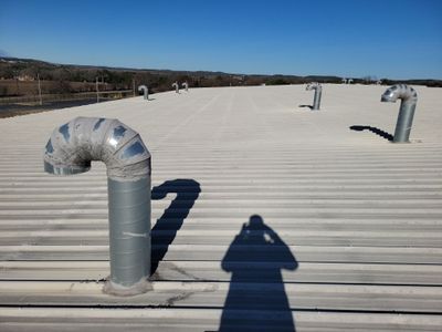 Wide view of metal roof with multiple ventilation pipes