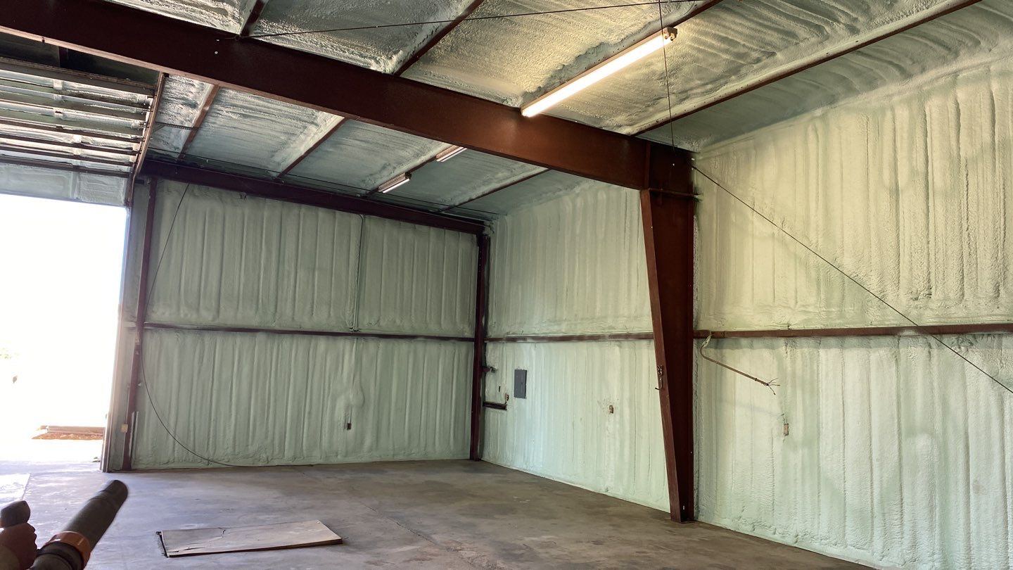 Spray foam insulation on inside of metal industrial building by Straight Edge Roofing Inc