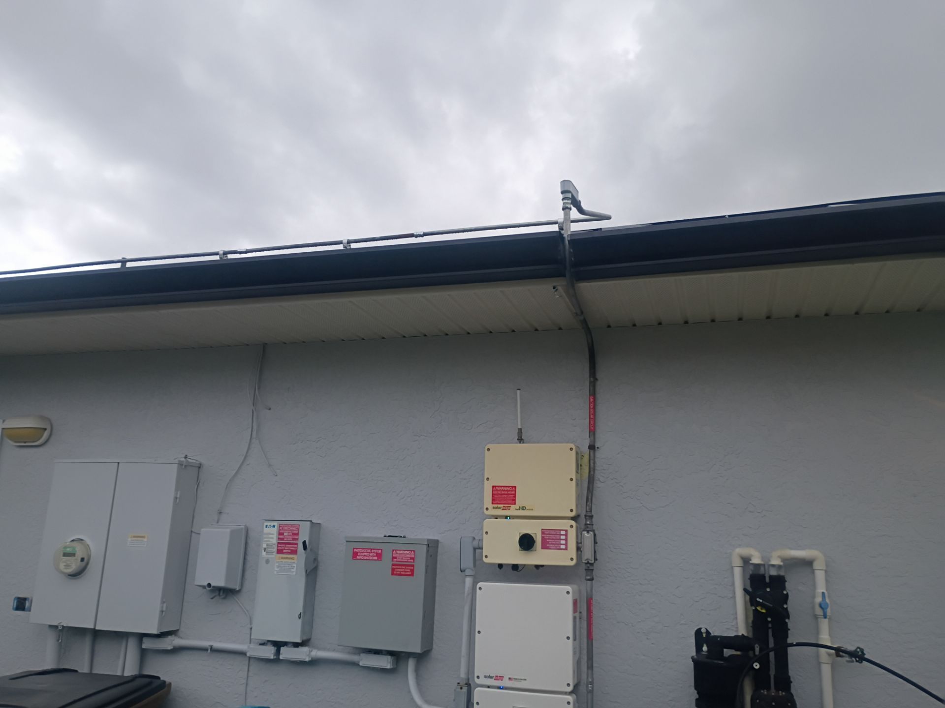 Black Seamless Gutters and White Downspouts in Cape Coral FL by Gutter Professors