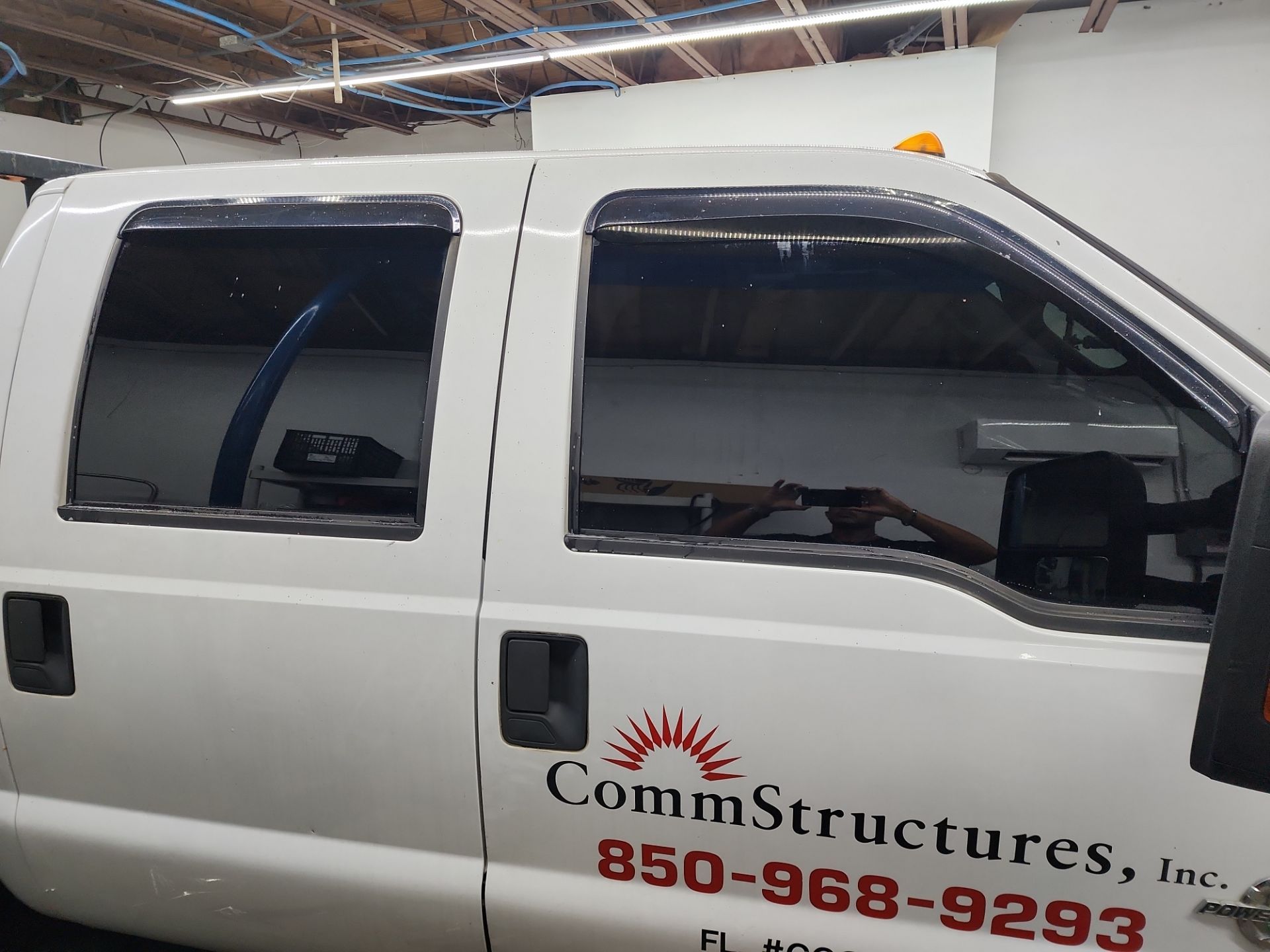 the image shows a truck with freshly tinted windows the company is applying window tinting to the truck's side windows the tinting is complete and looks darkened from the outside providing privacy and reducing the amount of sunlight entering the vehicle