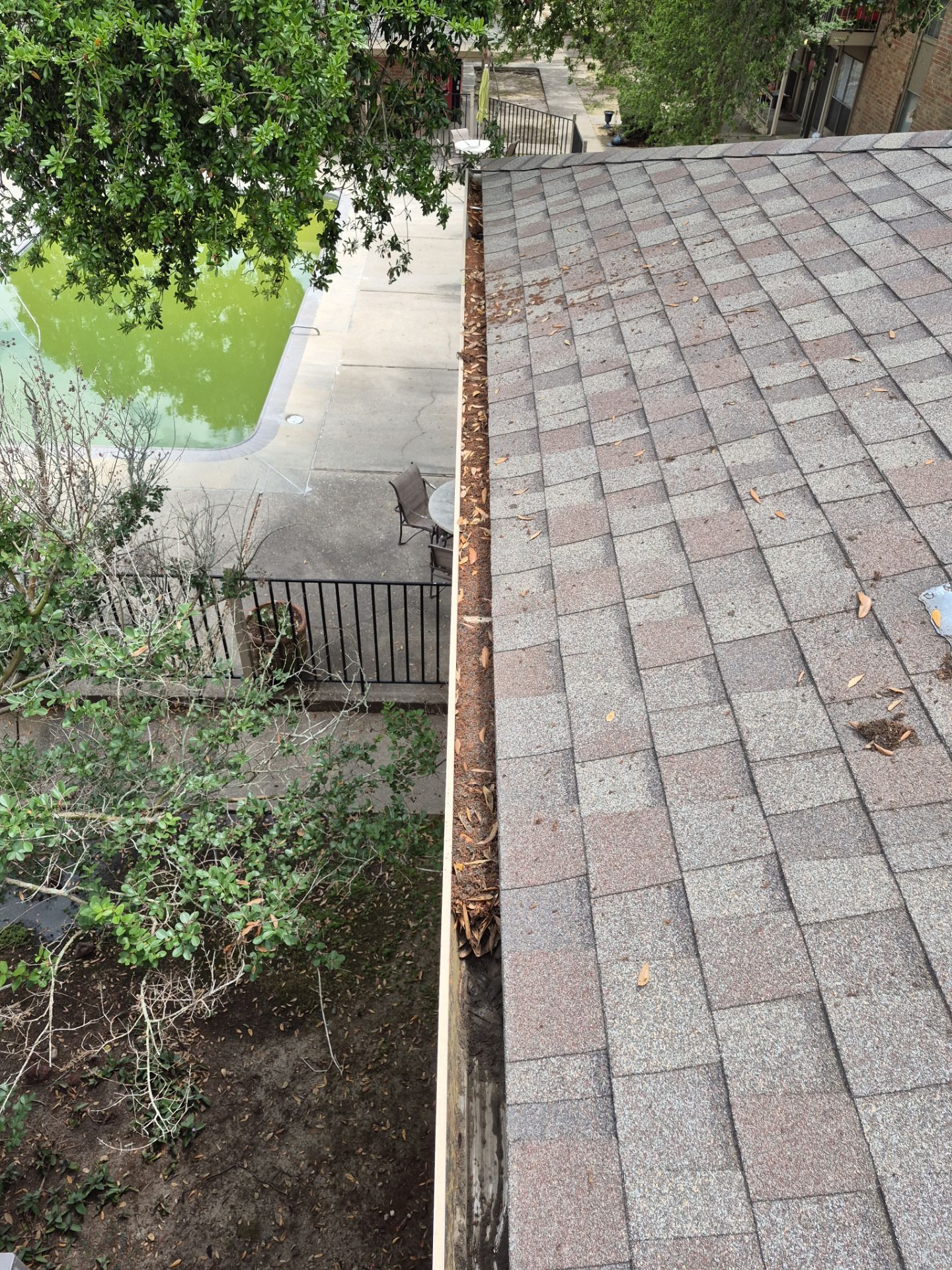 Commercial gutter cleaning Shreveport, LA before photo with filled gutters