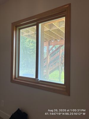 Residential Sliding Window Installation With Natural Wood Trim