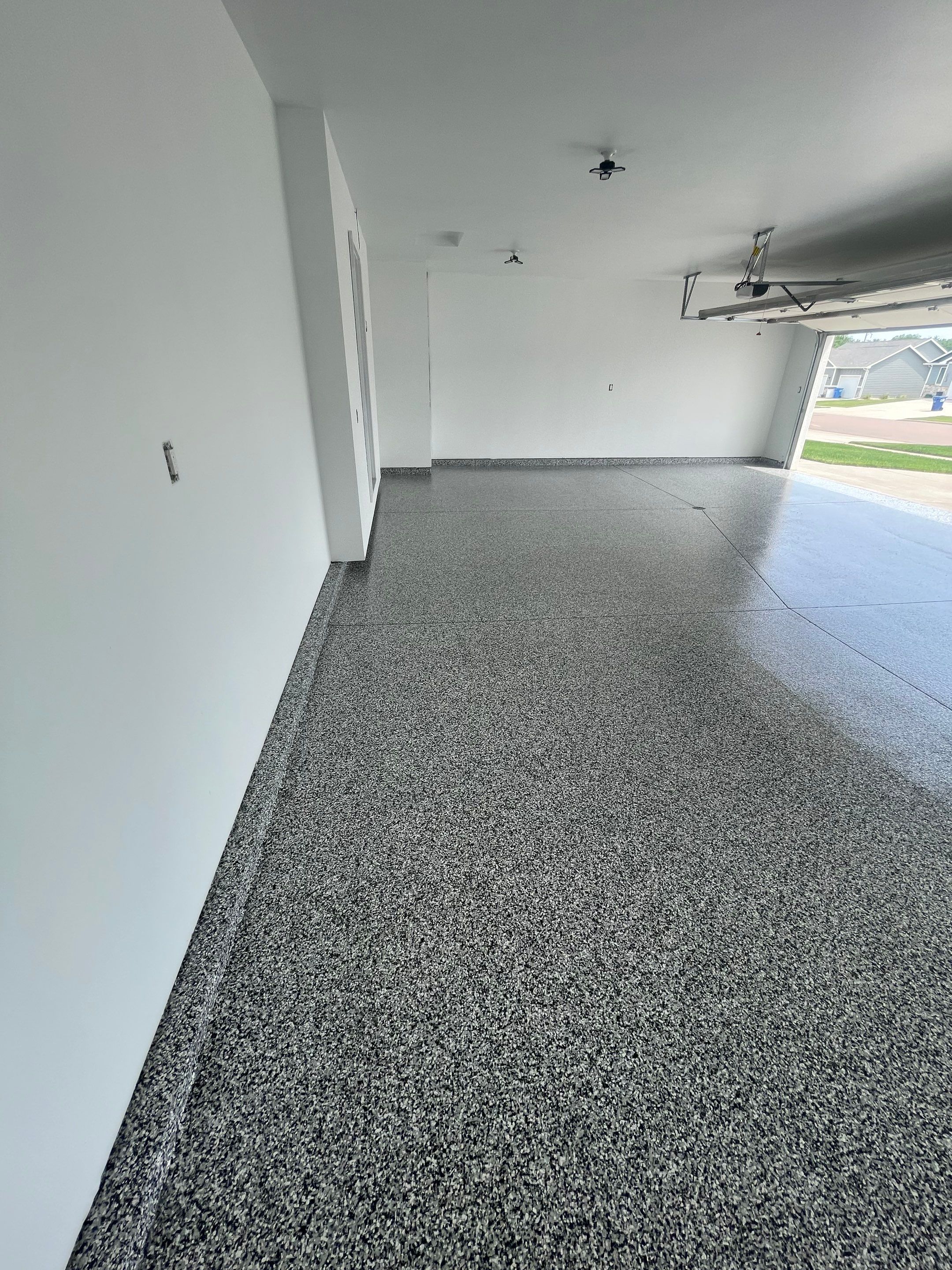 Grey Flake Epoxy Garage Floor Coating in Sioux Falls by Select Painting, Coatings & Garage Cabinets