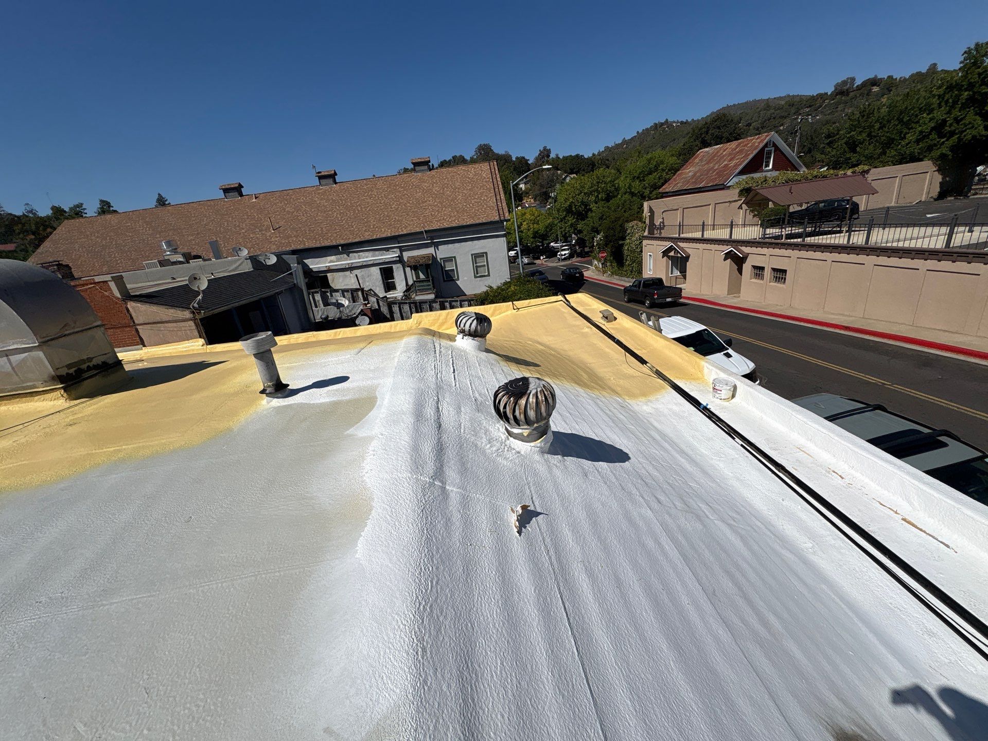 Foam and coatings on commercial roof by Straight Edge Roofing Inc