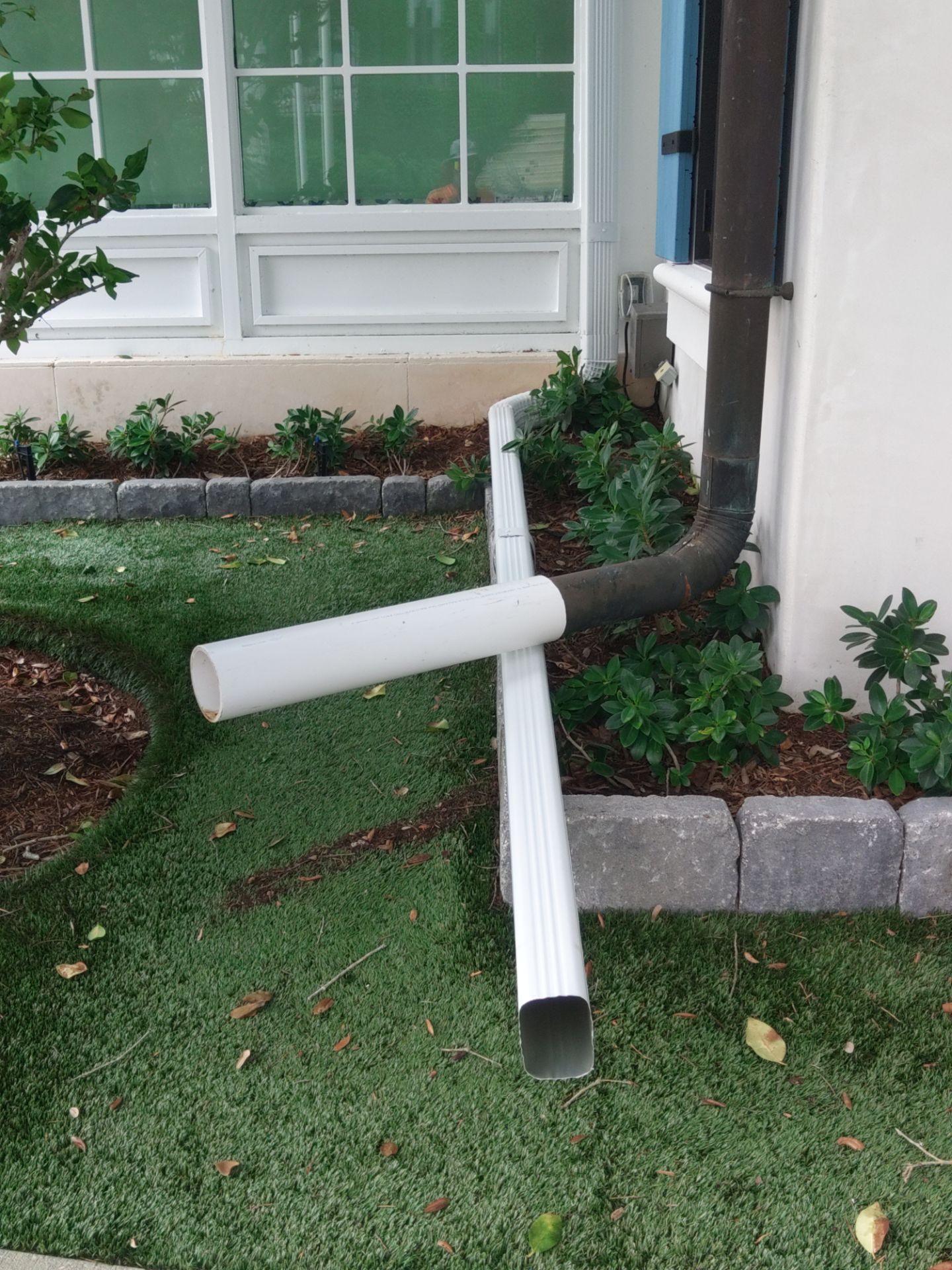 Seamless aluminum gutter installation in Sarasota, FL using 3x4 elbow downspouts combined with round downspouts by Gutter Professors