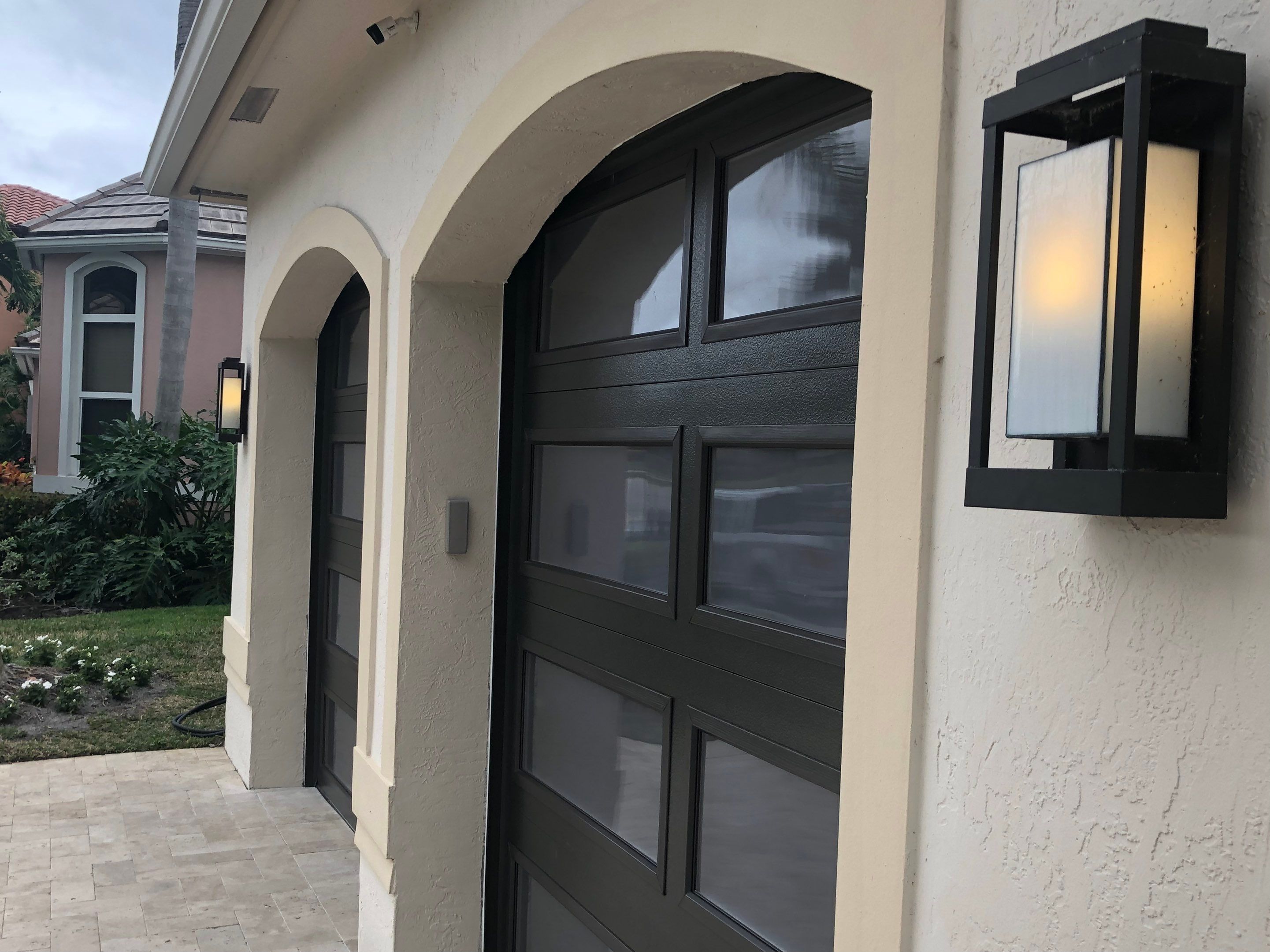 Modern Bronze Garage Door Installation With Frosted Glass in Boca Raton by The Door Doctor of South Florida, Inc.