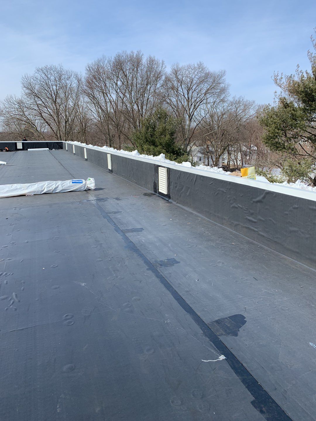 Commercial Roofing Installation using EPDM with white gutters by A Plus Exterior