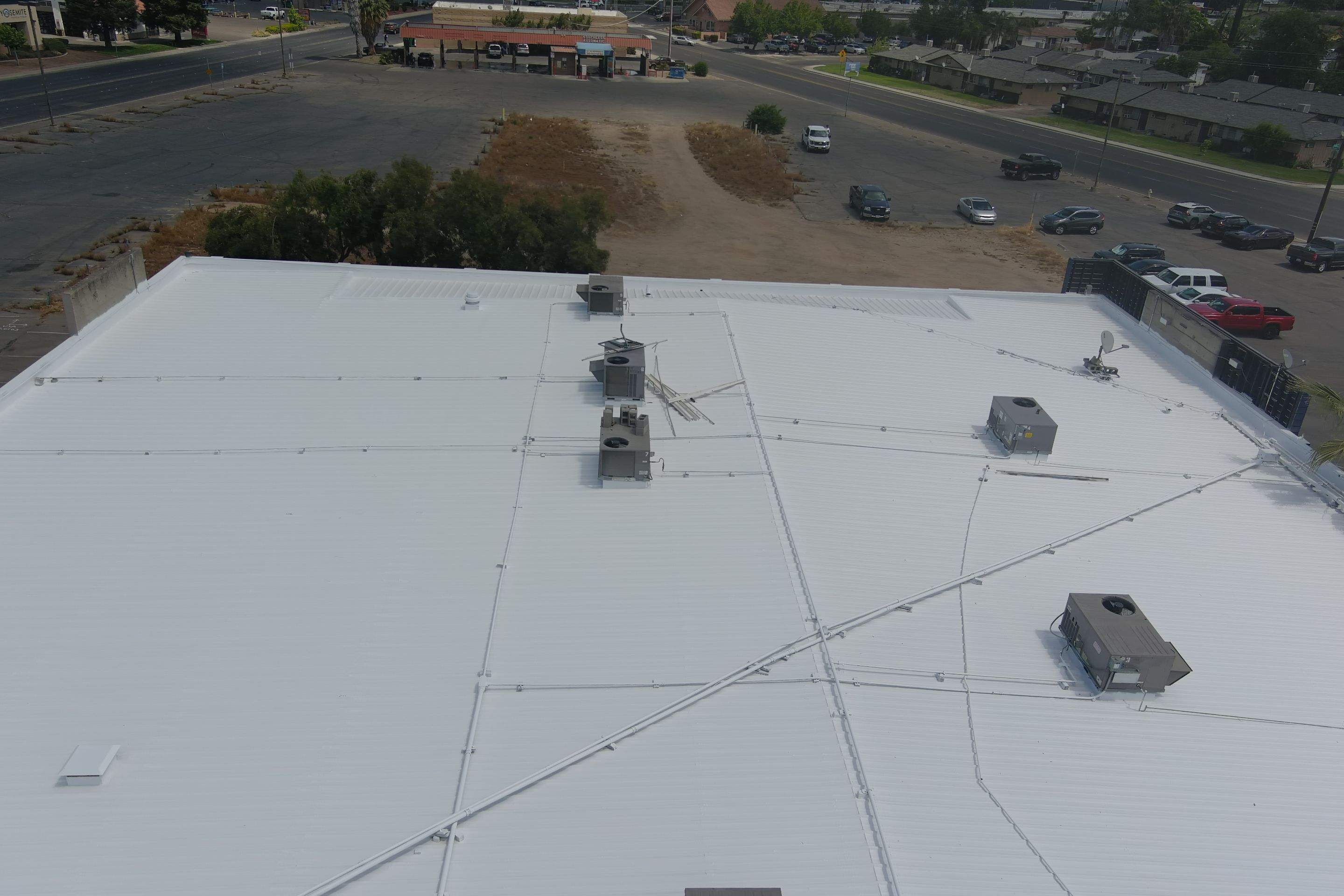 Metal roof restoration on commercial roof using Conklin Benchmark/ PUMA XL acrylic coatings over metal and foam by Straight Edge Roofing Inc