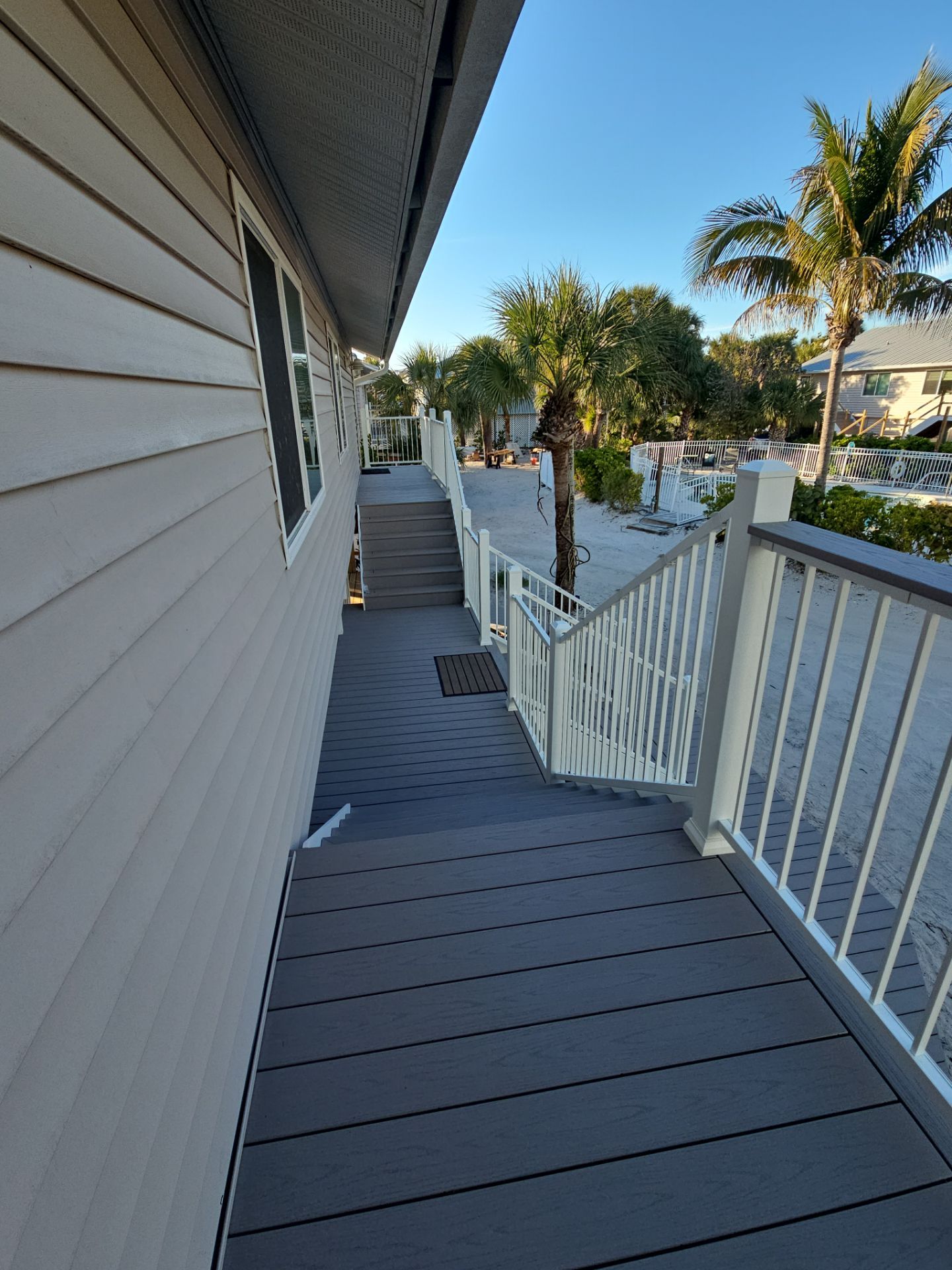 Elevated Home Deck Reconstruction With White Aluminum Railings in Placida by Smirnov Construction Inc