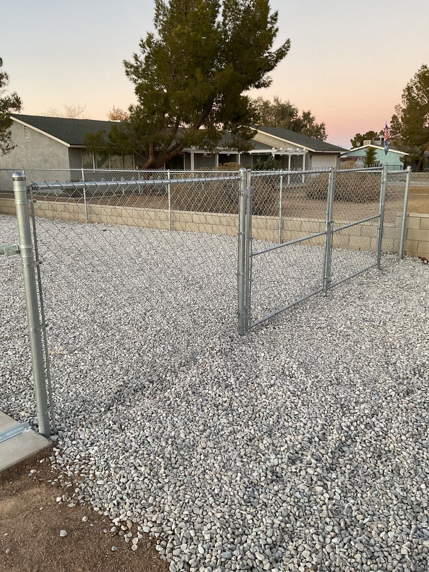 Sleek chain link fence installation with a solar motorized gate by Fence Guys Inc.