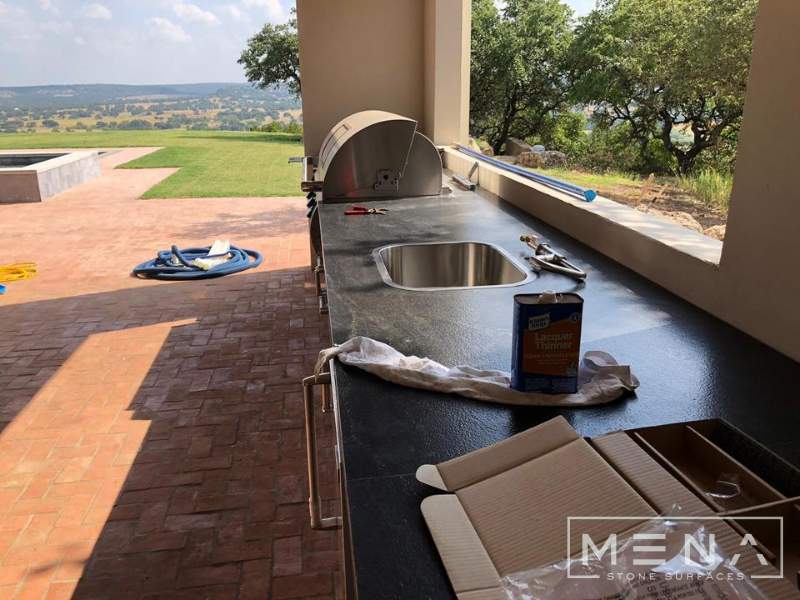 Kitchen, outdoor kitchen and pool brick floor installation by Mena stone surfaces