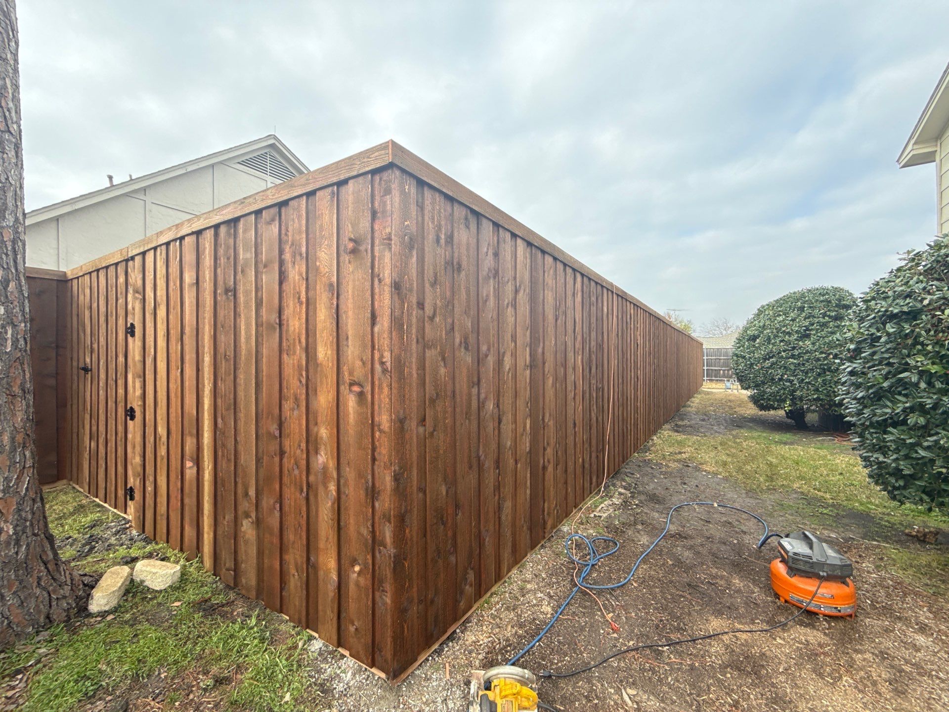 Pre-Stained board on board w/ trim and kickboard using 1x4 cedar trim by Grizzly Fence And Patio