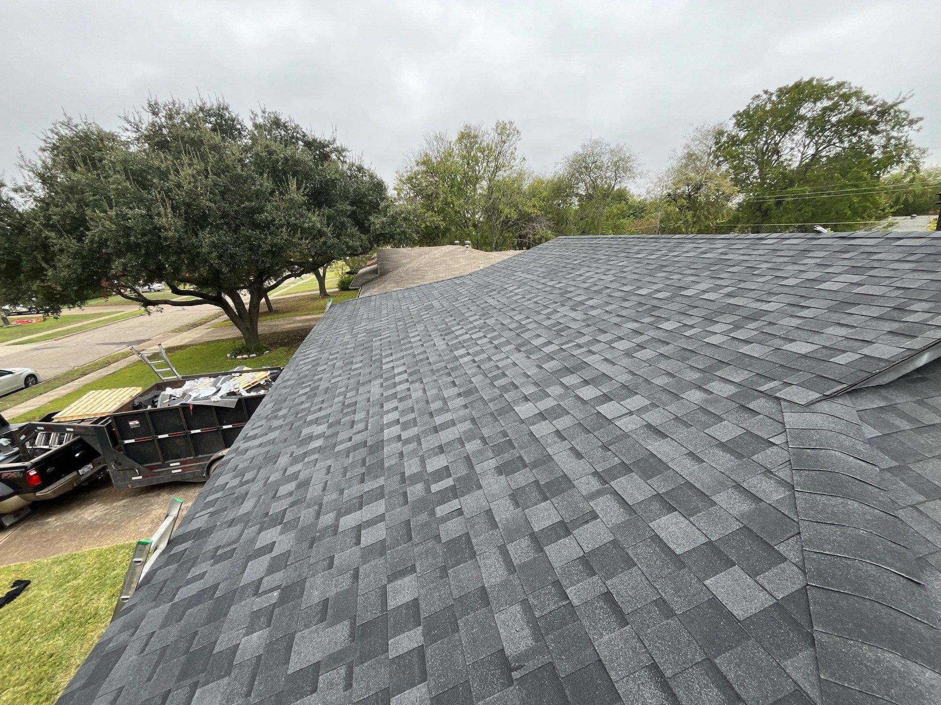 White brick/black accents with IKO Granite Black by Tejas Roofworks + Restoration