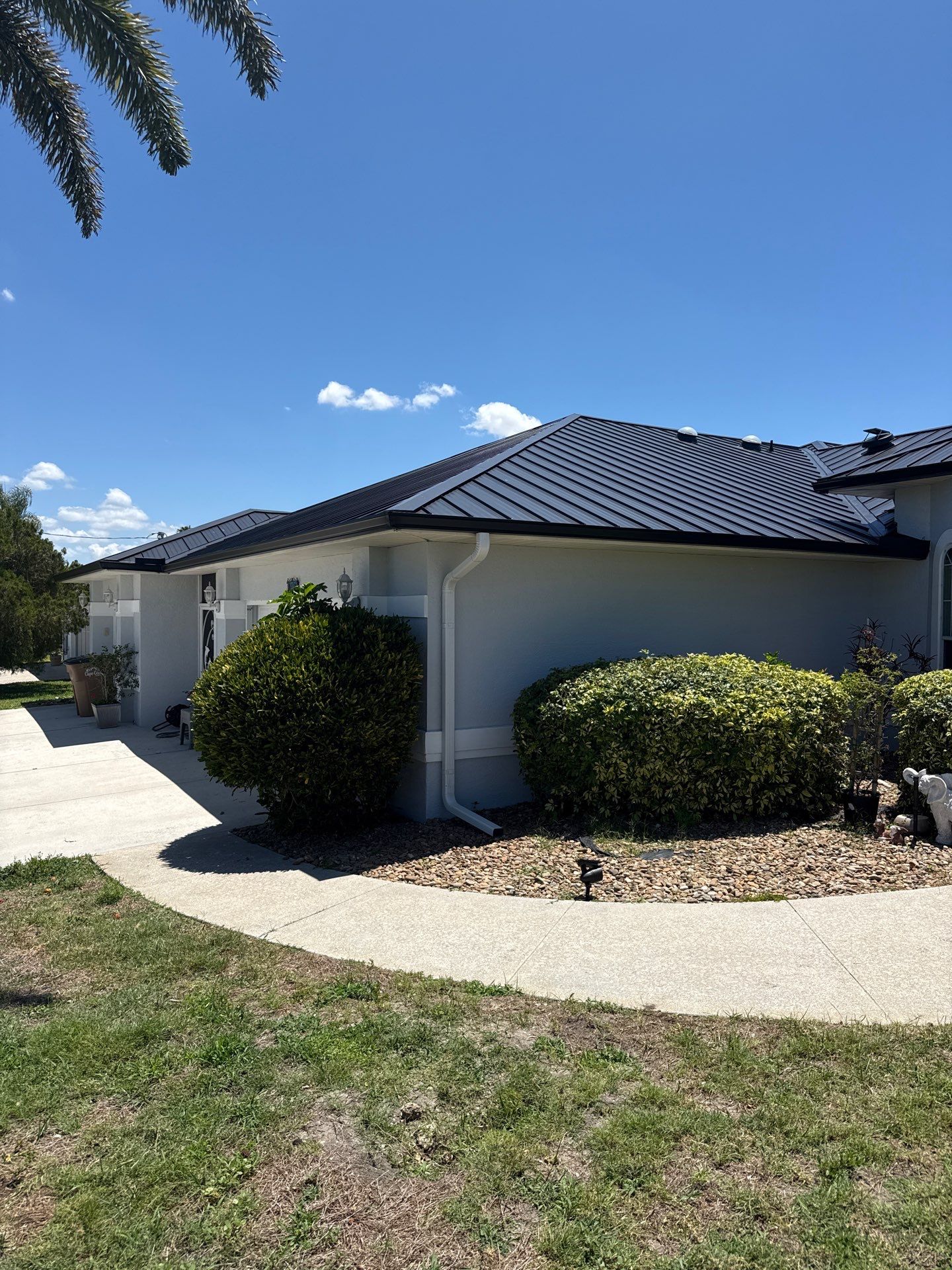 Black Seamless Gutters and White Downspouts in Cape Coral FL by Gutter Professors