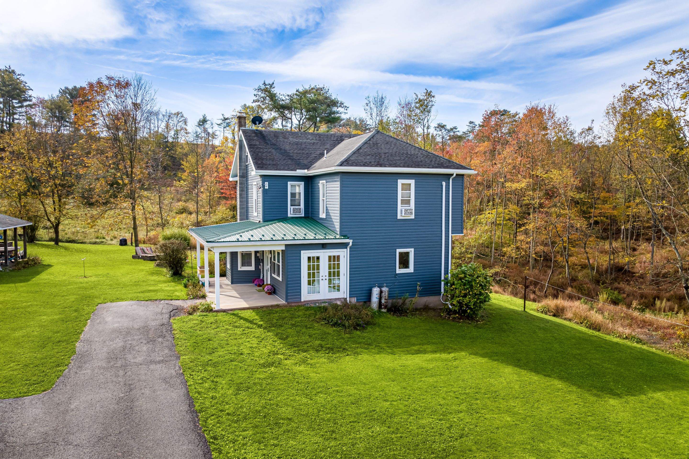 Porch roof [green] and new siding by Esh Builders