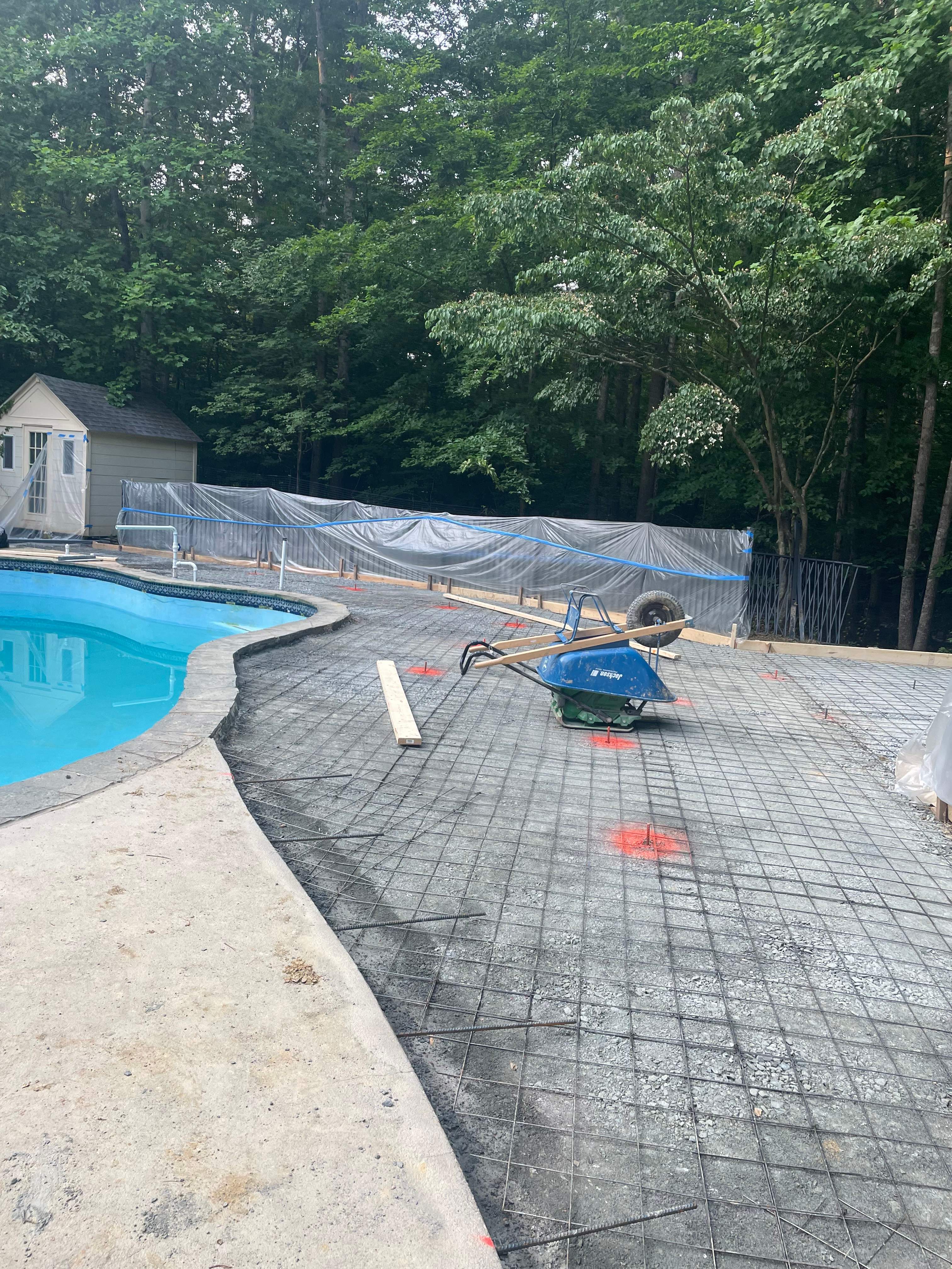 Pool Surround remodel with retaining walls, new waterfall and water slide by Fairfax Contractors, LLC