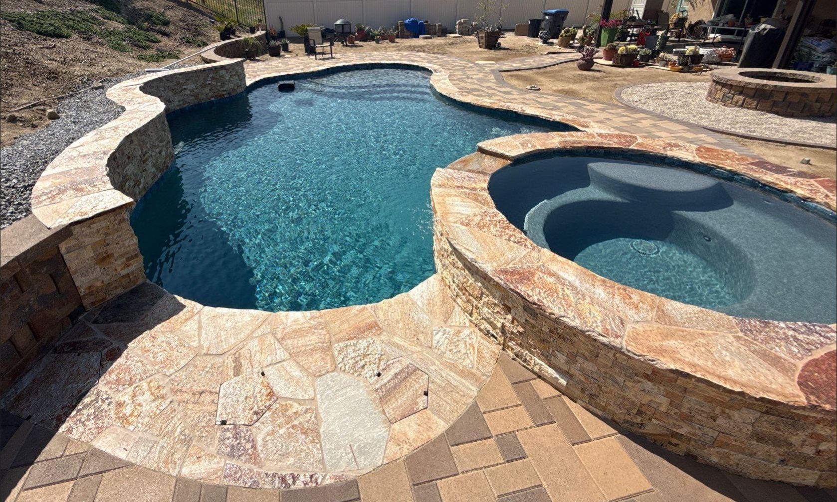 Freeform pool and spa with paver decking by Premier Pools and Spas Temecula