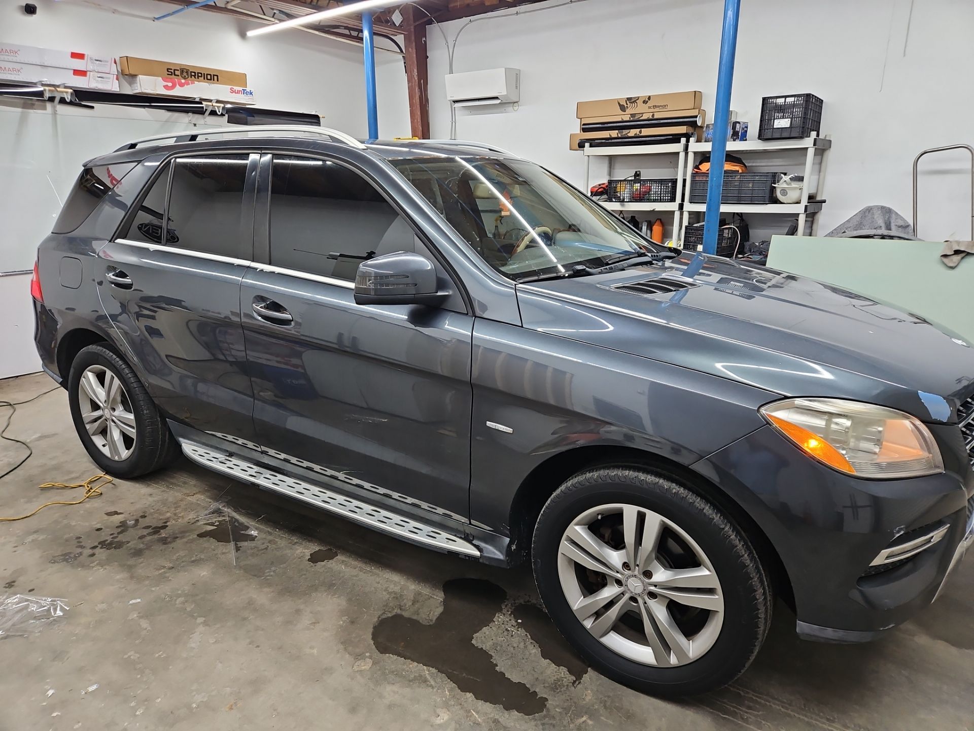 the image shows a car receiving window tinting service the windows are being carefully covered with a specialized film the tint will enhance privacy and reduce heat inside the vehicle the tinting process also improves the car's appearance while protecting the interior from harmful uv rays the vehicle appears to be clean and well maintained ready for the tint installation