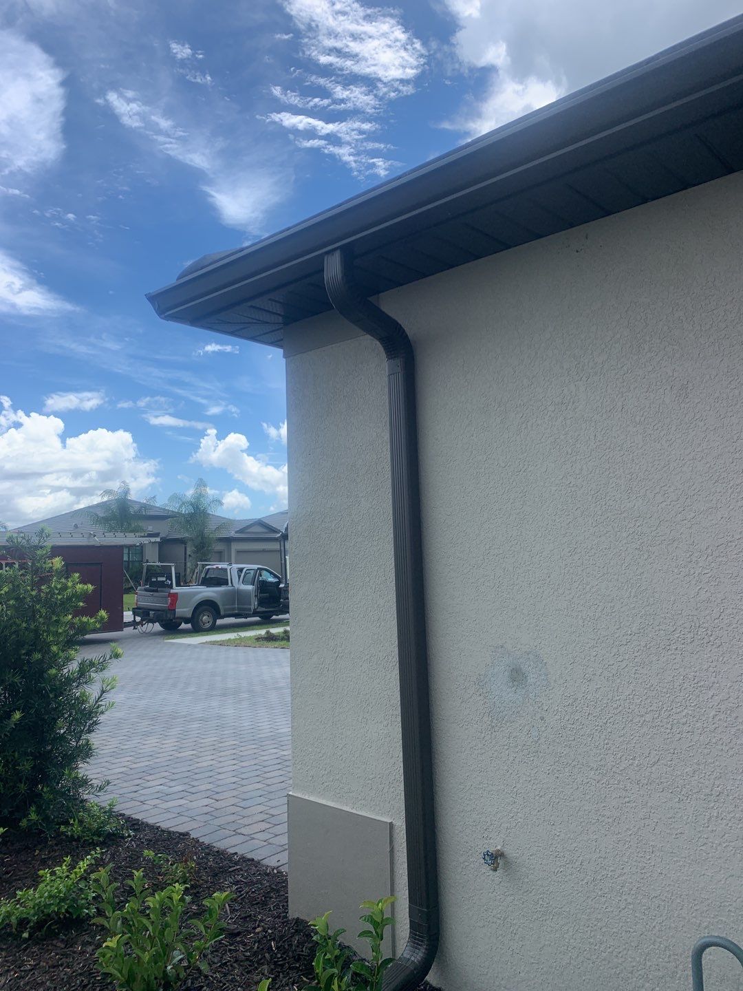 Seamless brown gutter and downspouts installation in Estero, FL  by Gutter Professors
