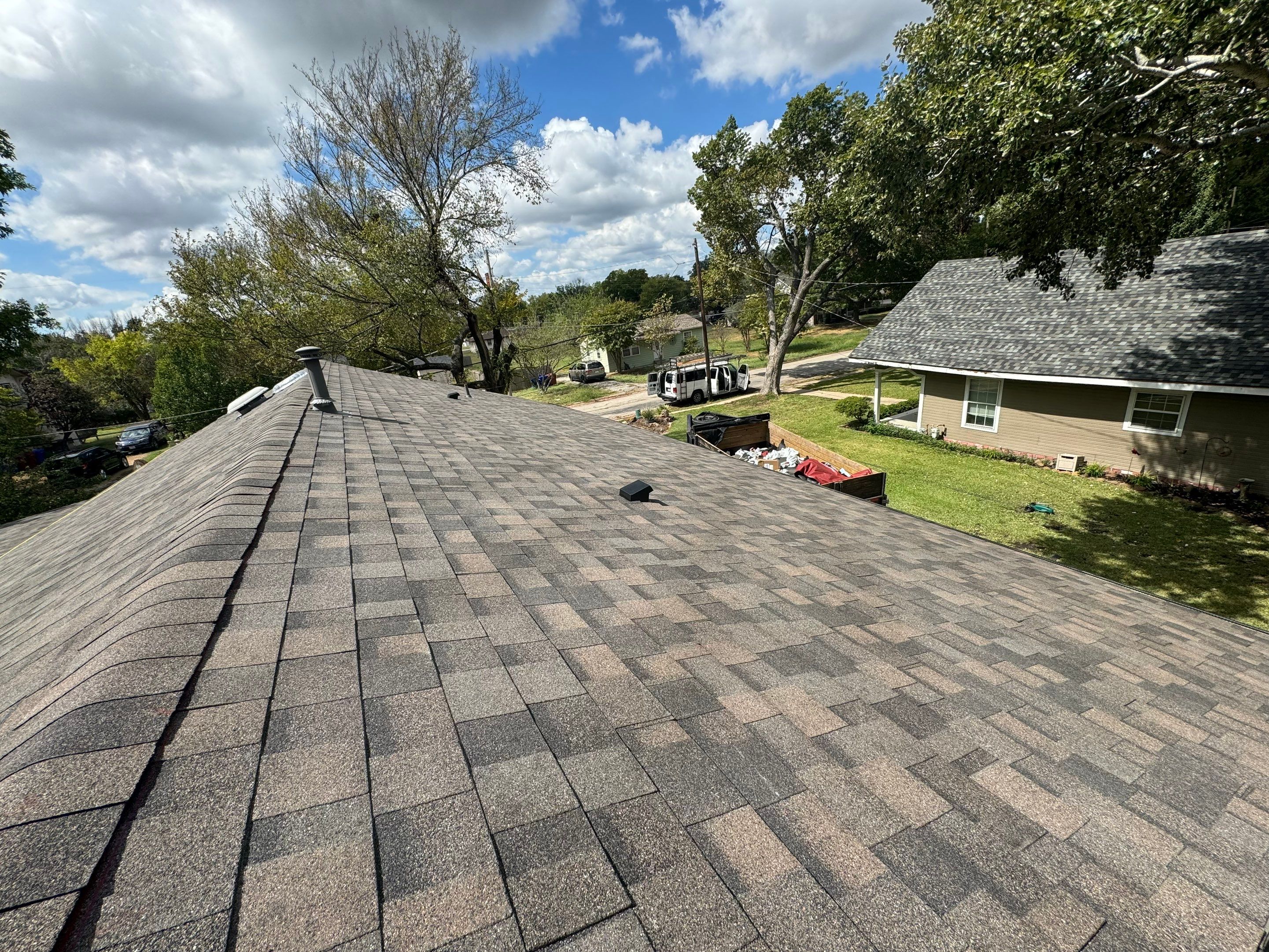 IKO Driftshake-Dark green siding house by Tejas Roofworks + Restoration