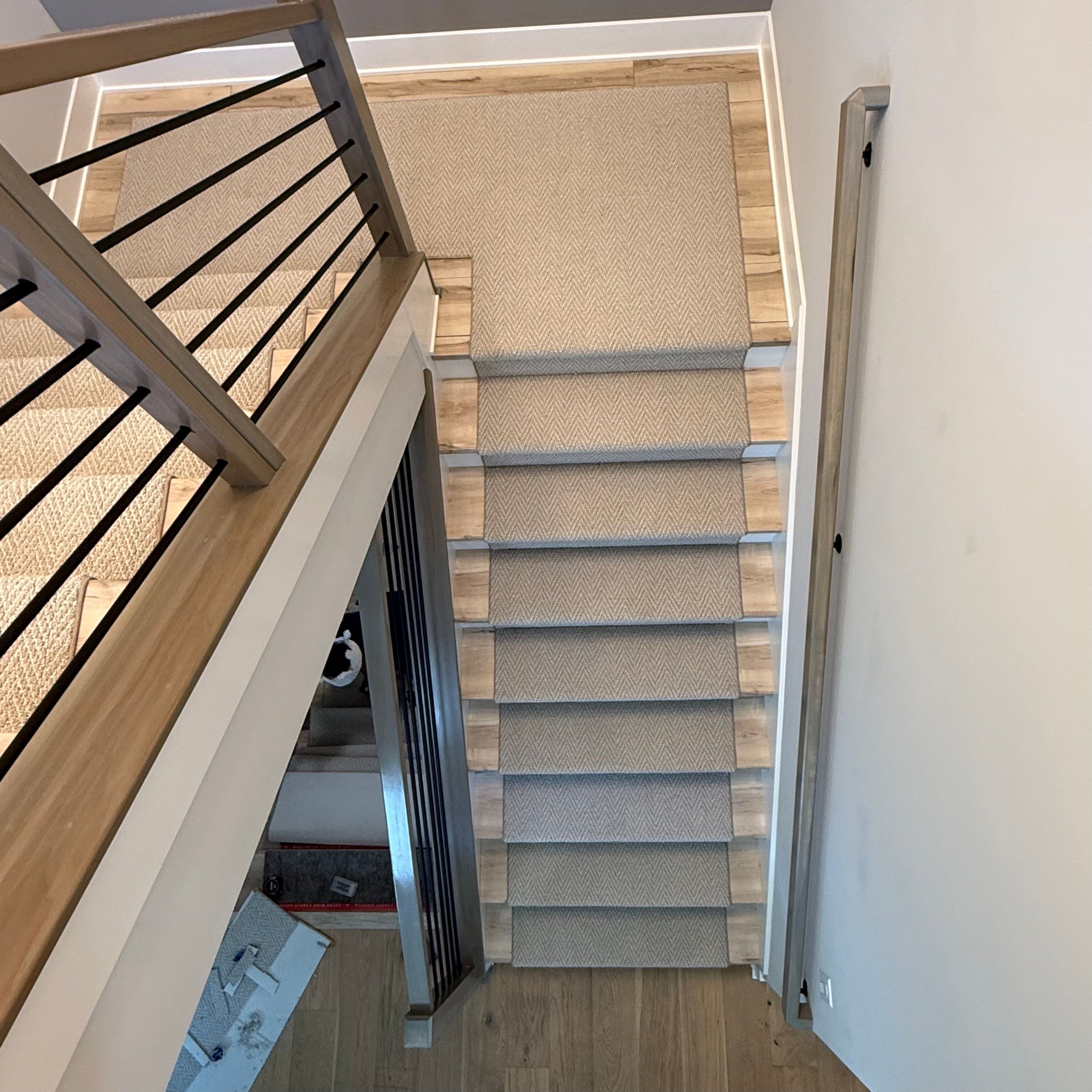 Fishers Staircase Renovation Featuring Custom Herringbone Runner and Modern Railing by Brothers Floor Covering INC.