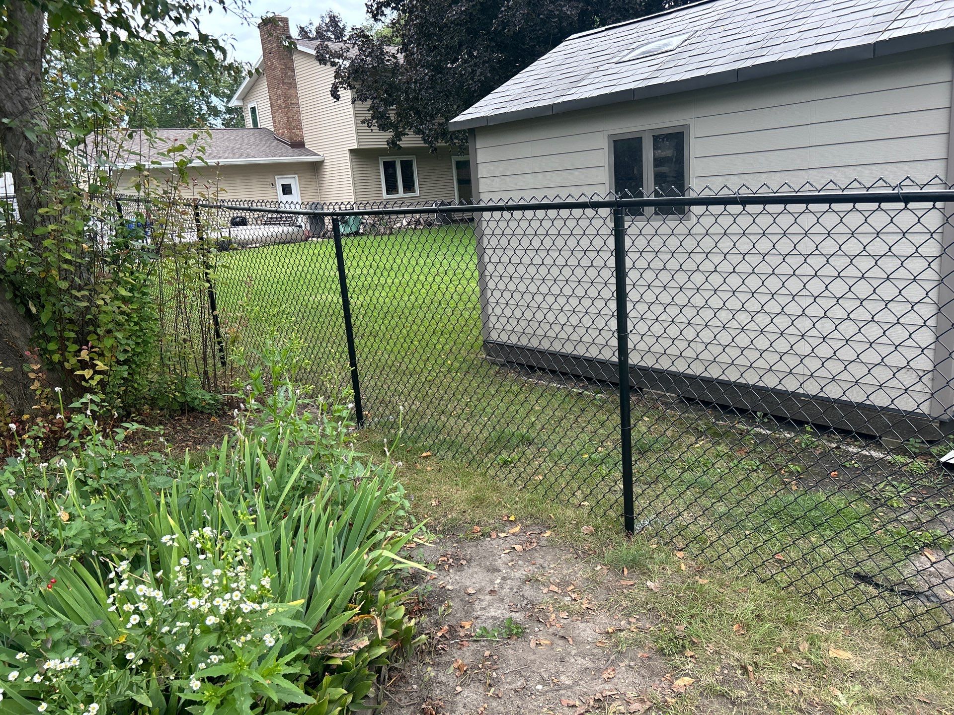 Black Vinyl-Coated Chain Link Fence Installation in Waterloo by Perfect Picket Fence and Stain