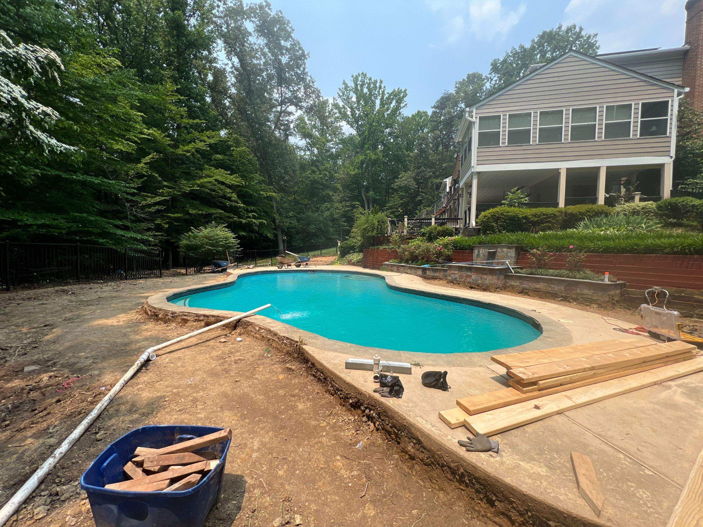 Pool Surround remodel with retaining walls, new waterfall and water slide by Fairfax Contractors, LLC