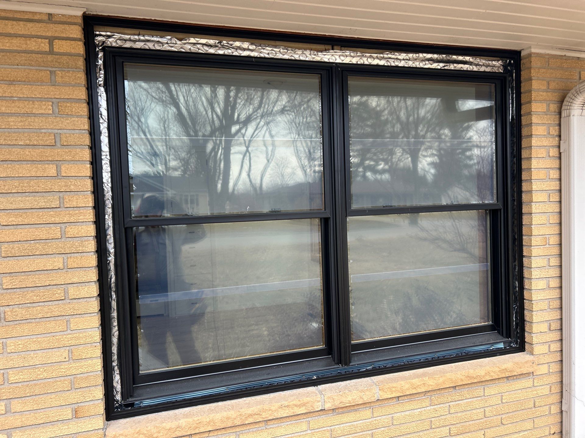 Black-Frame Pella Lifestyle Upgrade on a Partial Brick Home by United Windows and Siding LLC