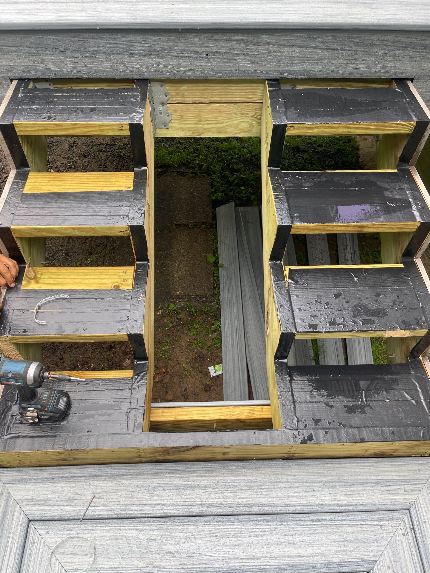 Raised Gray Composite Deck and Staircase Construction in Pocono Summit, PA by Herts Roofing & Construction