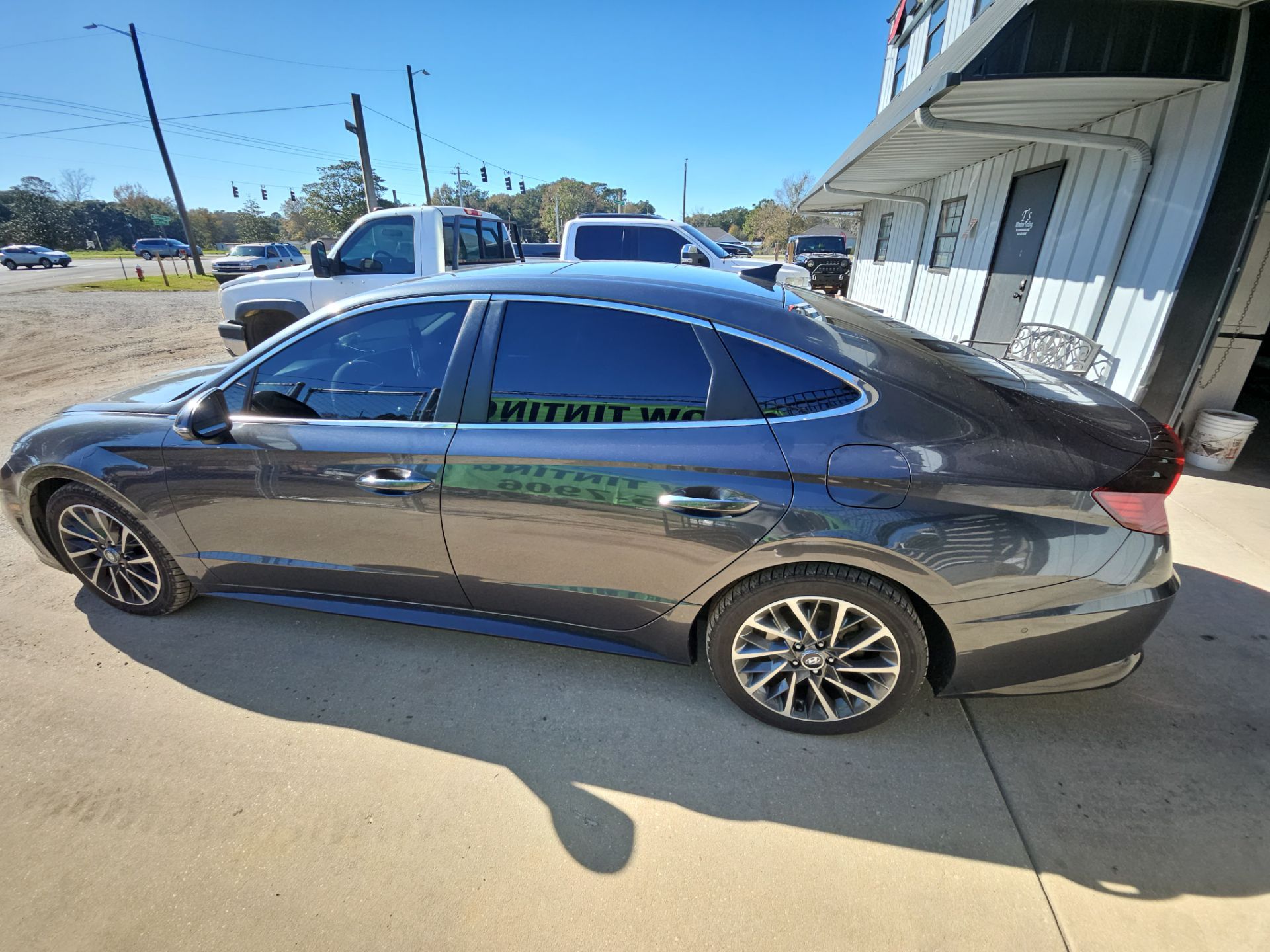 the image shows a car that is undergoing window tinting service provided by t's window tinting the darkened windows suggest that the film is being applied to enhance privacy and reduce glare the sleek design of the vehicle indicates that the tinting is done on a modern sedan the process likely involves cleaning the windows before applying the tint film to ensure a smooth finish the tint appears to cover all the side and rear windows giving the car an upgraded look and feel