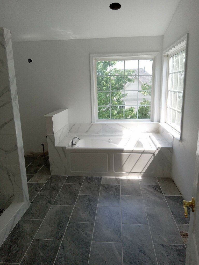 Bathroom Remodel using porcelain tiles , wood make vanetys , mirross , bathroom accessories  by Jesus Master Handyman LLC 