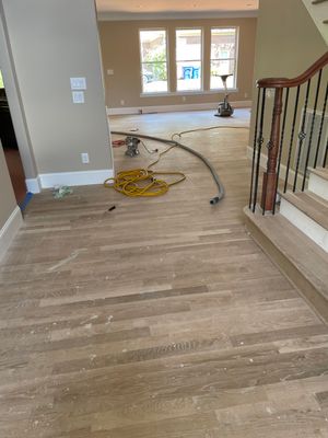 New white oak floors, stained a red tone. by Accent Custom Floors