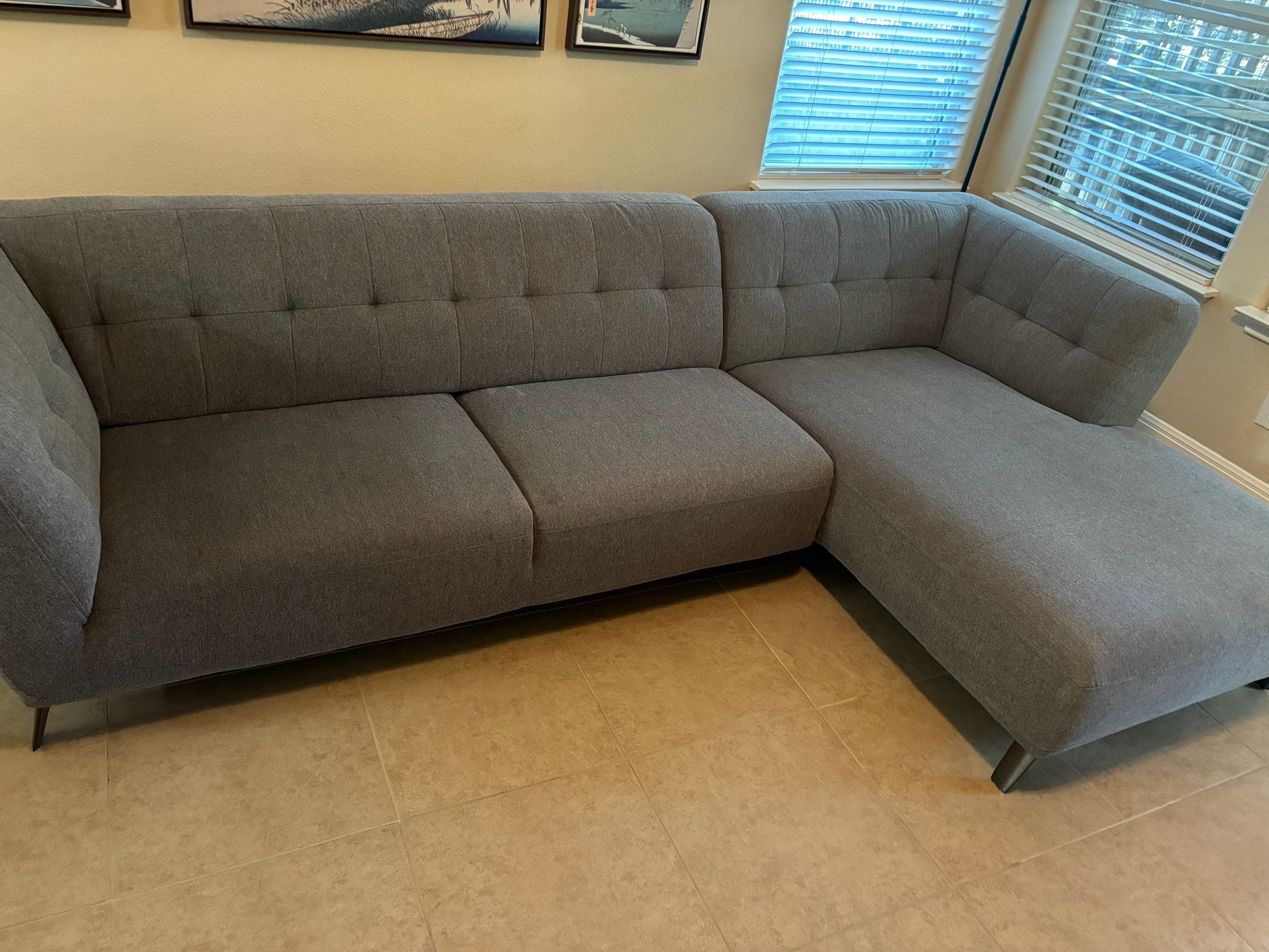 the service being done is upholstery cleaning on a fabric sectional sofa in a living room setting