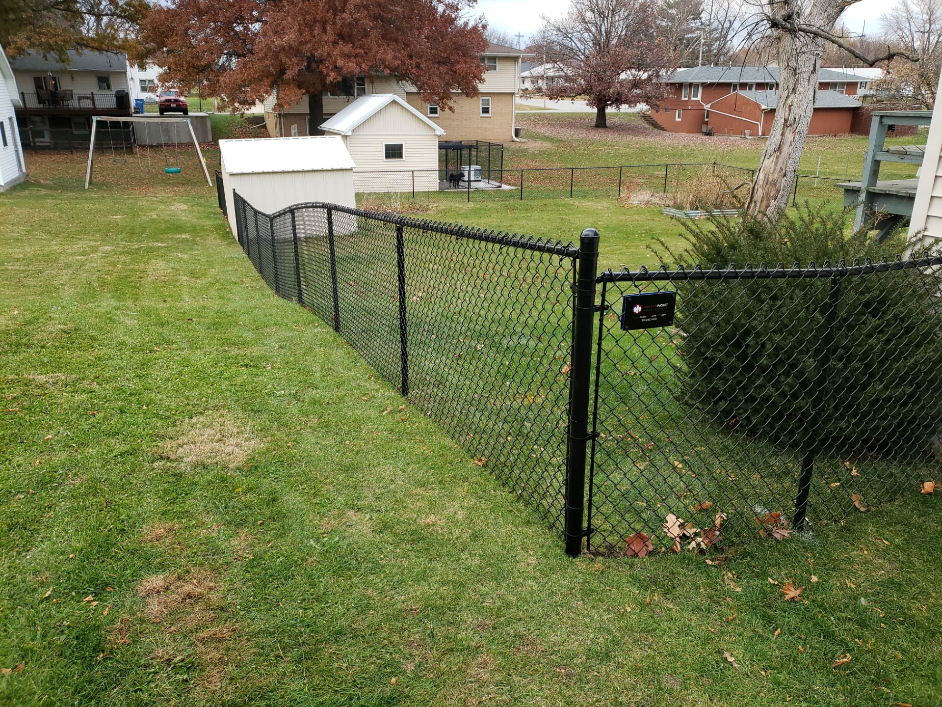 Residential Black Vinyl-Coated Chain Link Fence in Grundy Center by Perfect Picket Fence and Stain