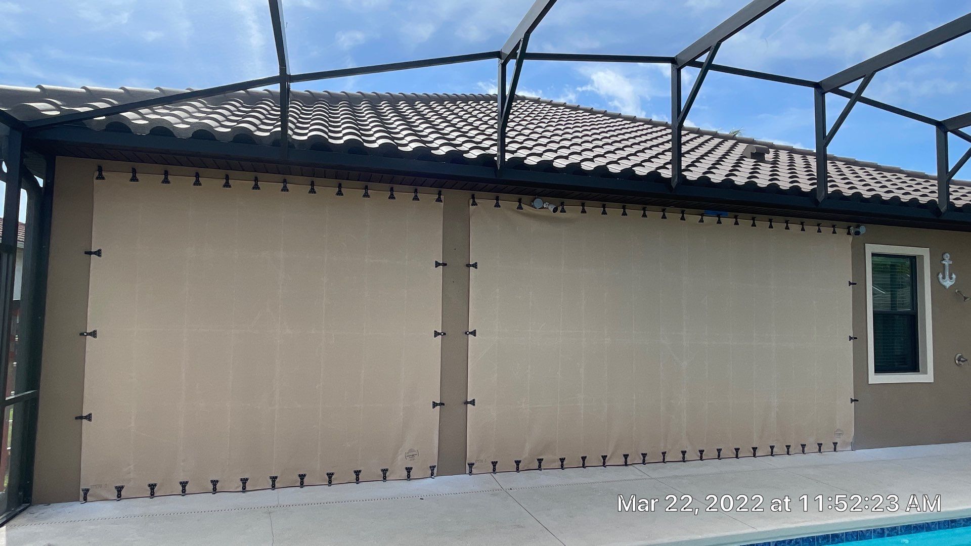 Bronze rolling screen with hurricane fabric by Smart Guard Shutters