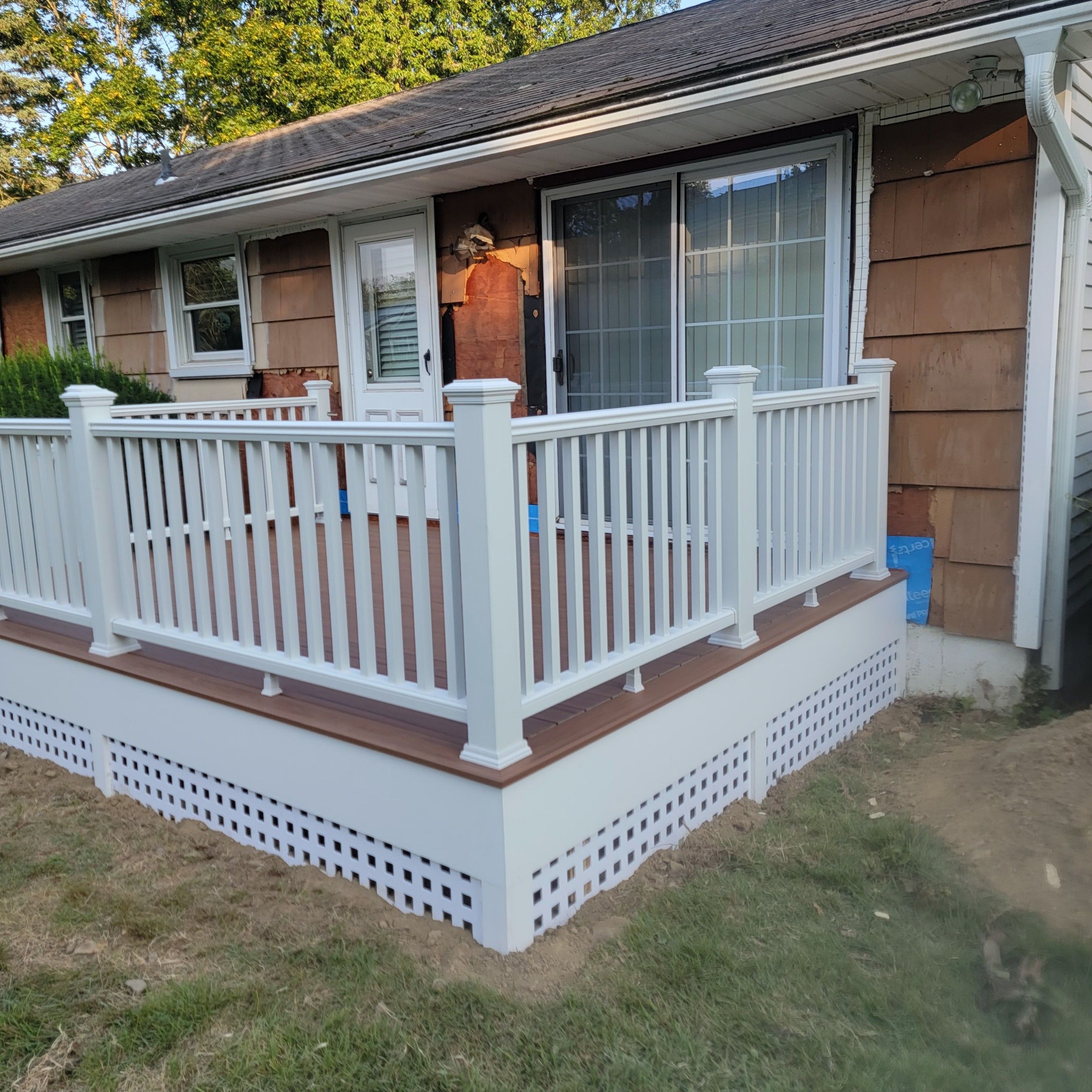 Deck Replacement using Trex Tropical Tiki Torch and White Transcend railings with lattice bottom by DiGiorgi Roofing and Siding Inc