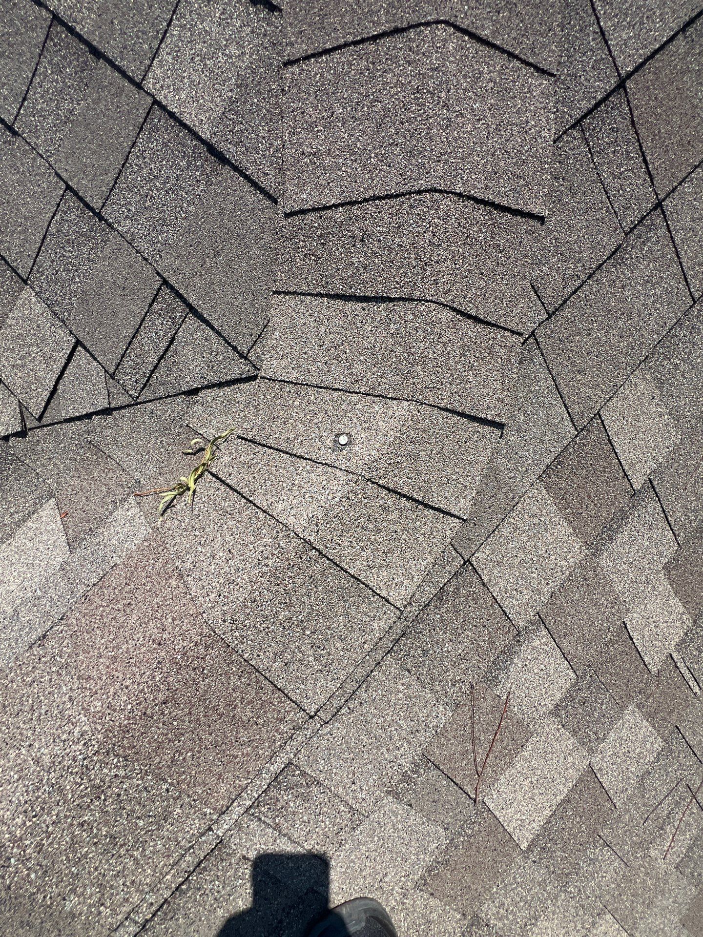 Grapevine-area roof showing wind damage before repair by Becker Roofing and Exteriors