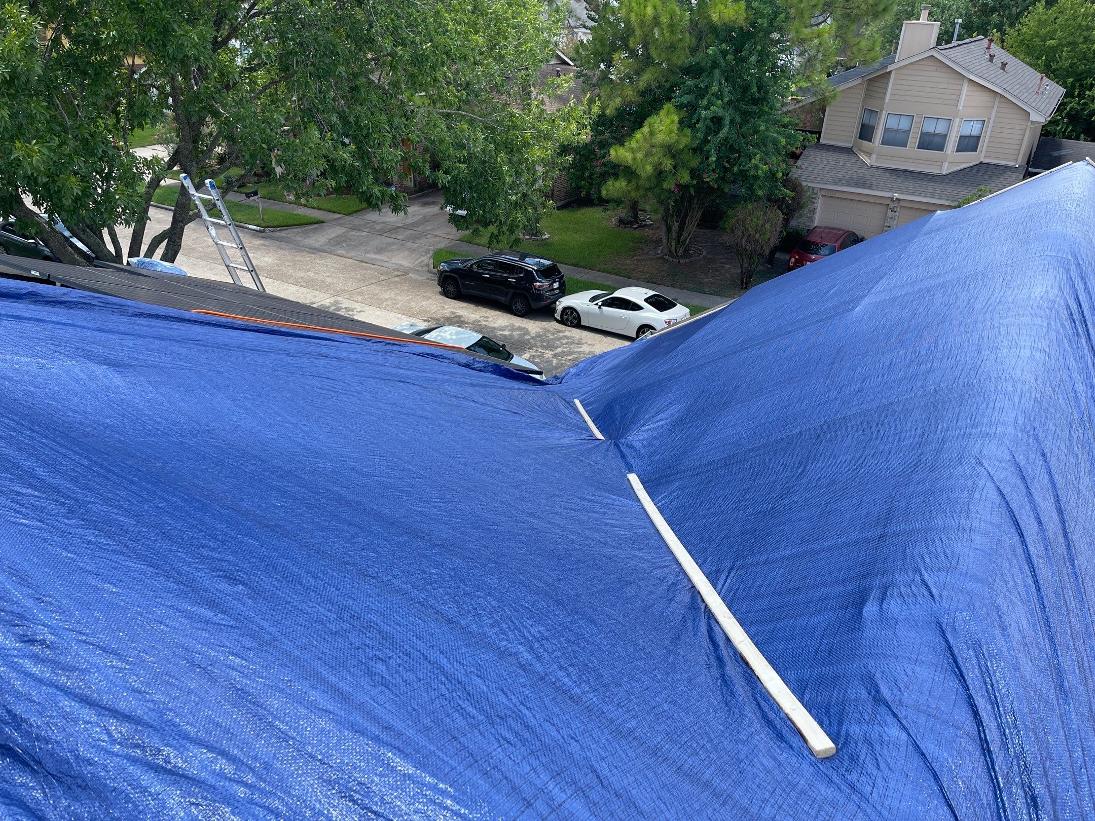 Placement of tarps on the roof. using TARP BLUE by V General Contractors 