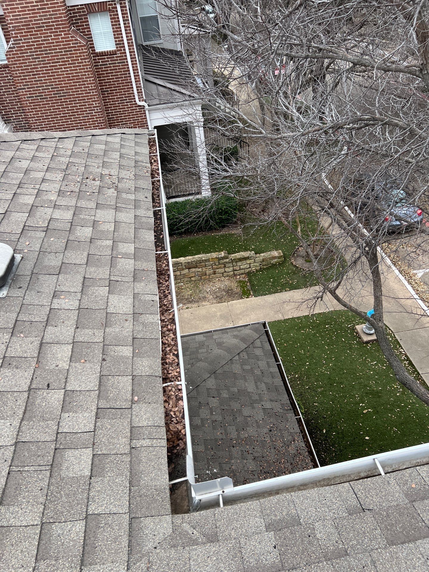 Commercial gutter cleaning Carrollton, TX before photo with filled gutters
