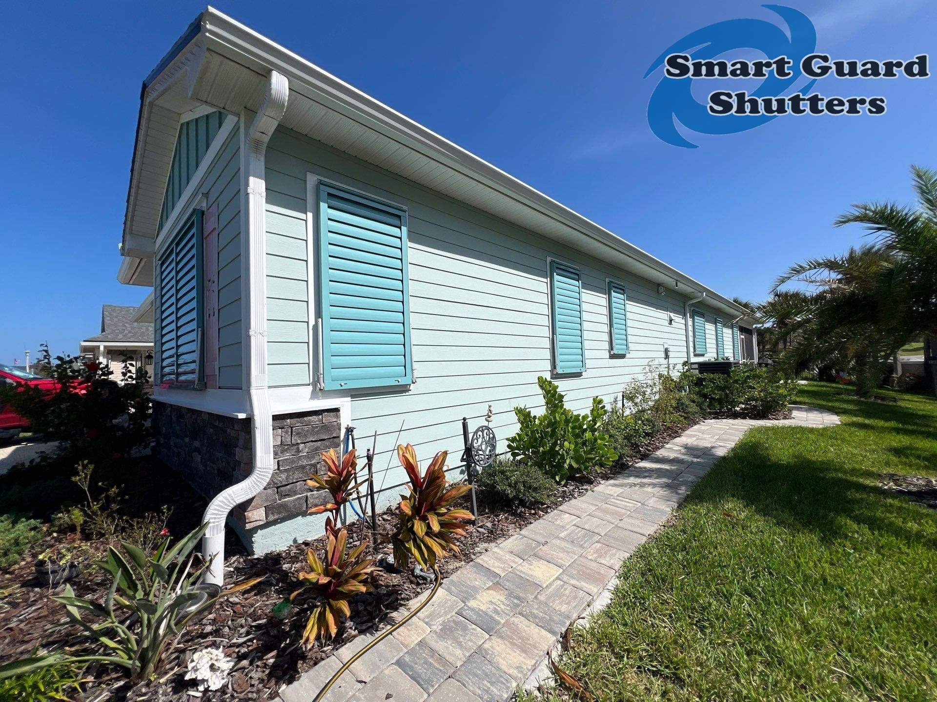 Impact Bahama Shutters in Pastel Turquoise by Smart Guard Shutters