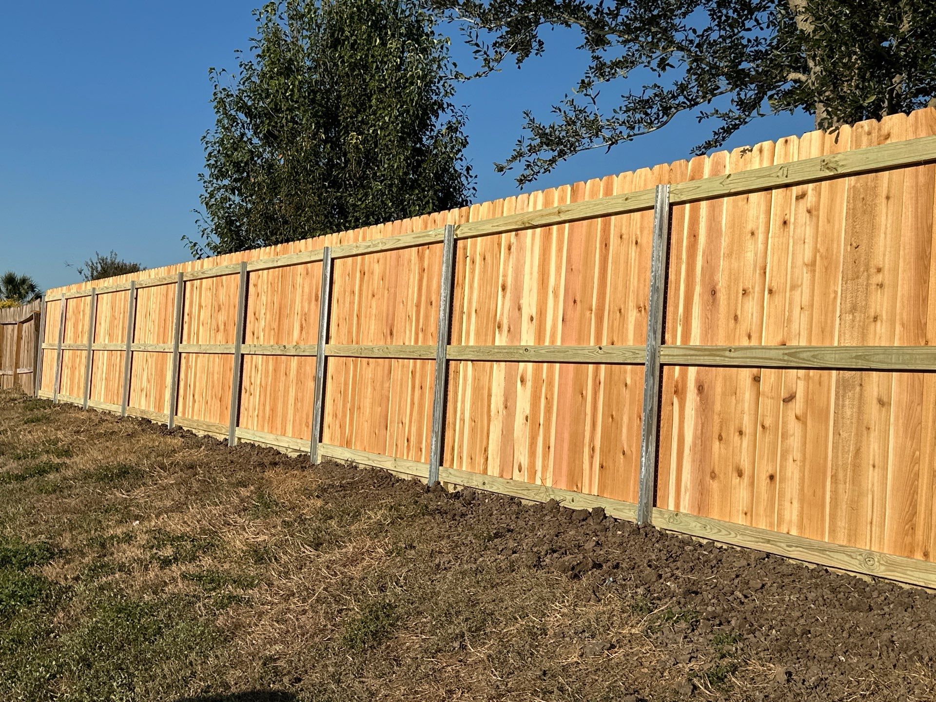 Beautiful Wood fence with metal posts by Tim's Fences
