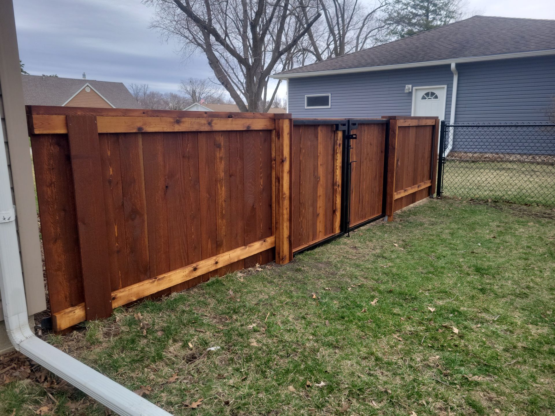 Dark Stained Cedar Privacy Fence and Custom Gates in Cedar Falls by Perfect Picket Fence and Stain