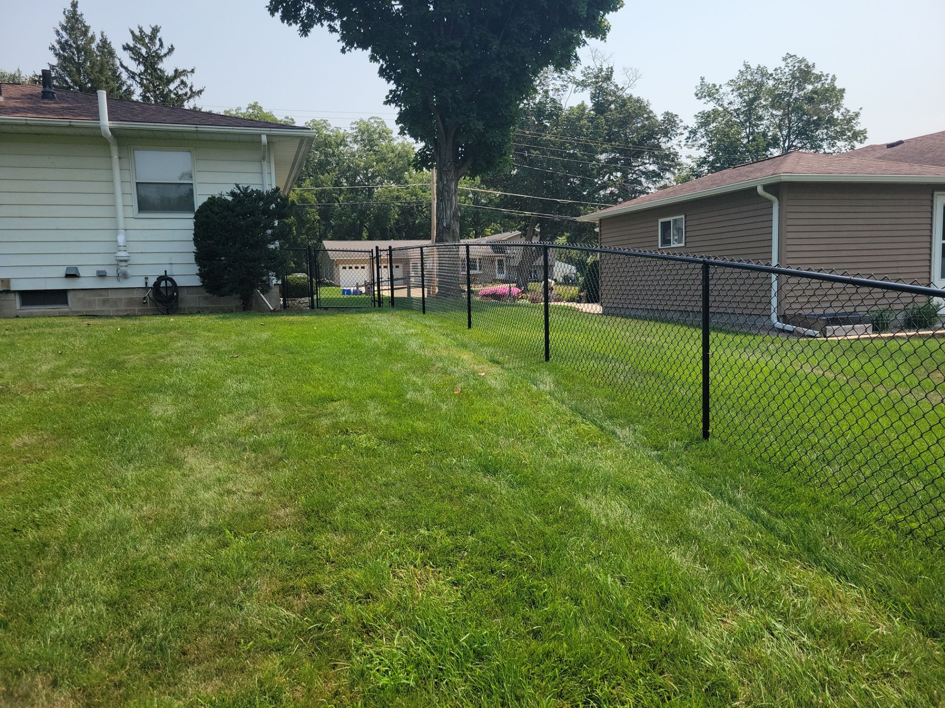 Black Vinyl-Coated Chain Link Fence Installation in New Hampton by Perfect Picket Fence and Stain
