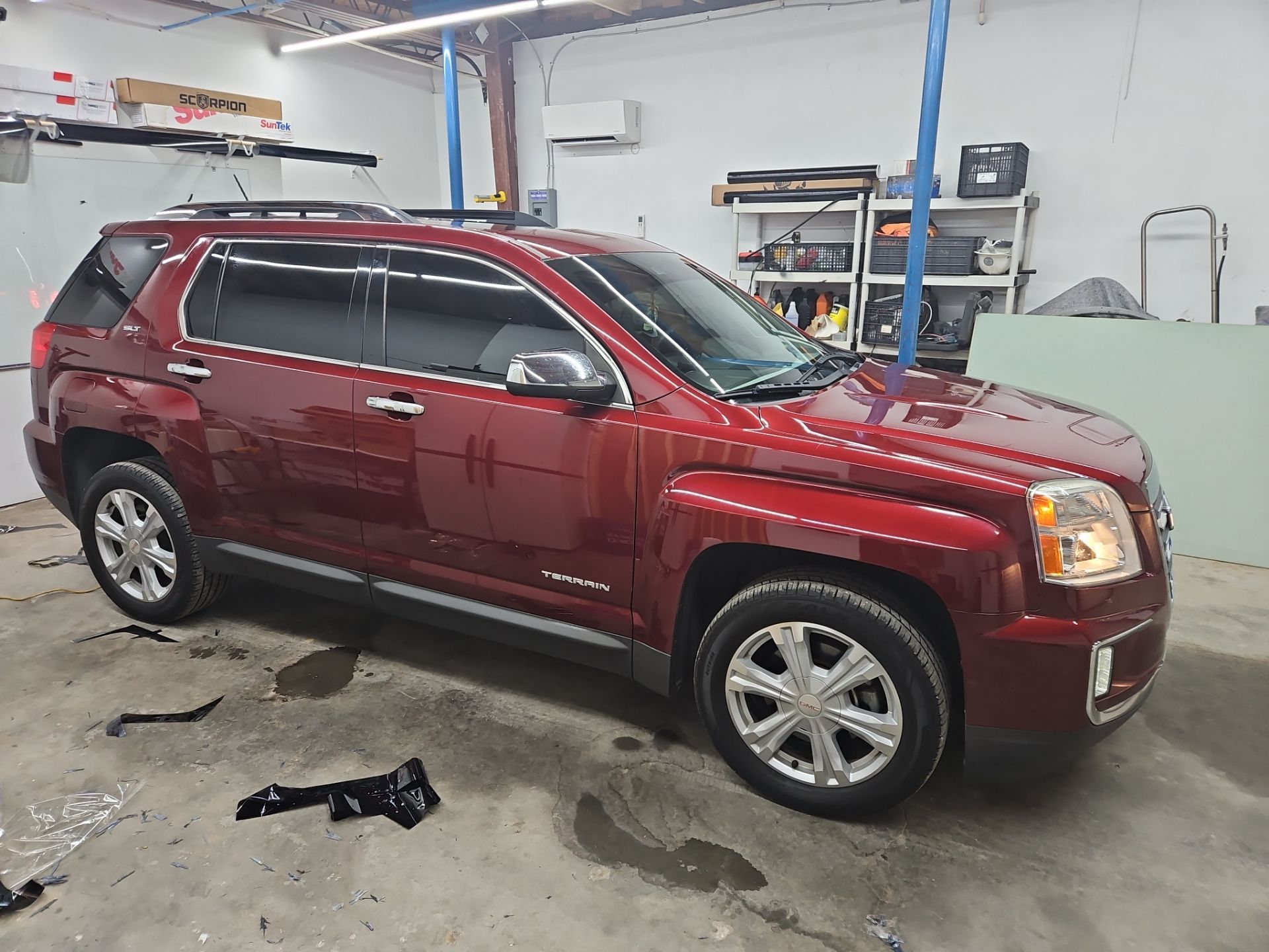 the car shown in the photo is having its windows tinted by a window tinting company this involves applying a thin darkened film to the windows of the car to reduce glare heat and uv radiation from entering the vehicle the process appears to be in progress with tinting materials visible on the floor nearby the windows being worked on