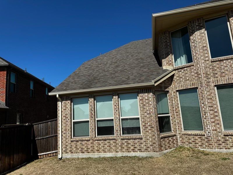 Brown brick/mixed stone with Malarkey Natural Wood by Tejas Roofworks + Restoration