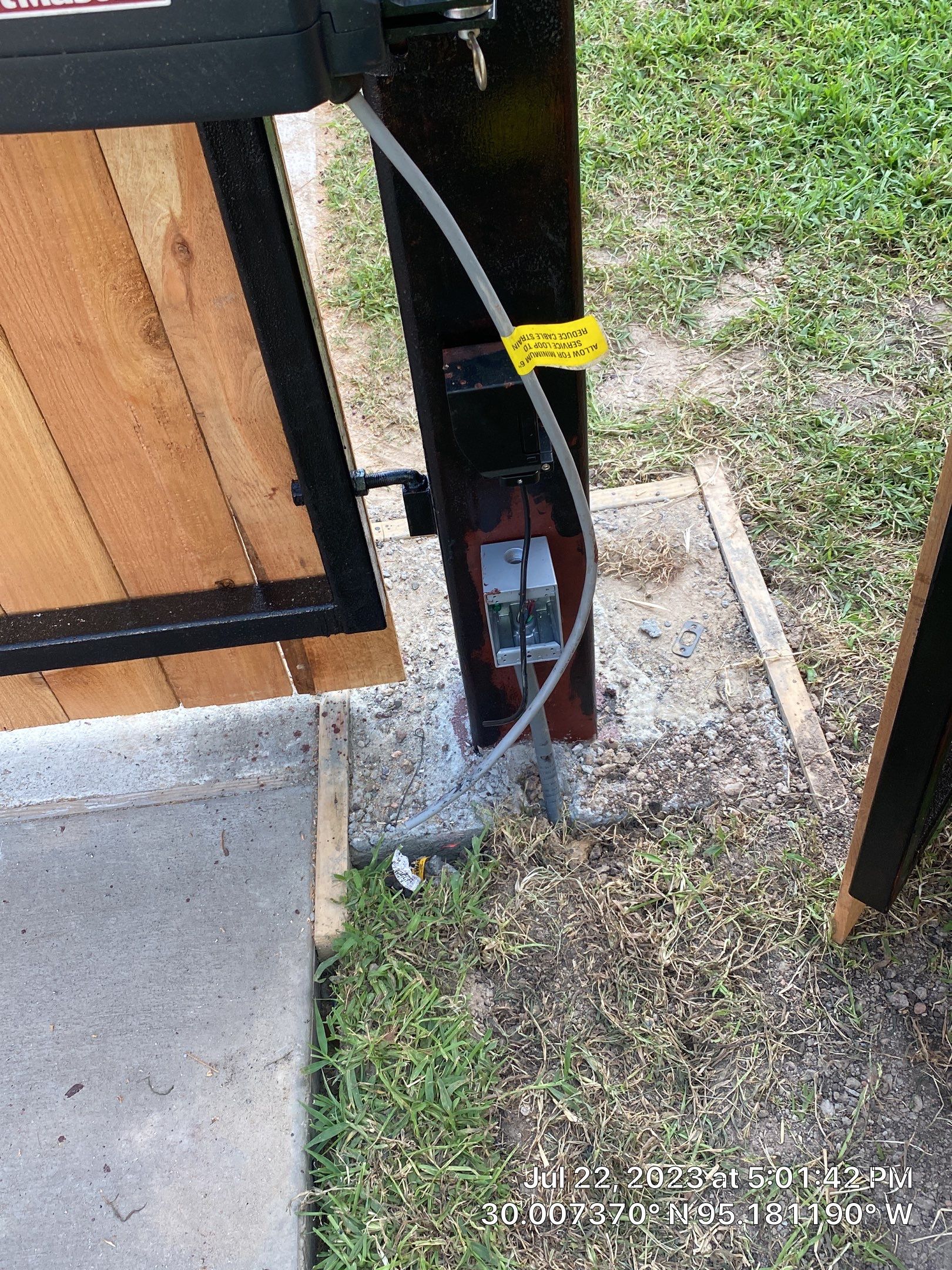 Complete metal driveway gate install with solar powered opener. Metal fence frame with Cedar Pickets by Astro Outdoor Designs 